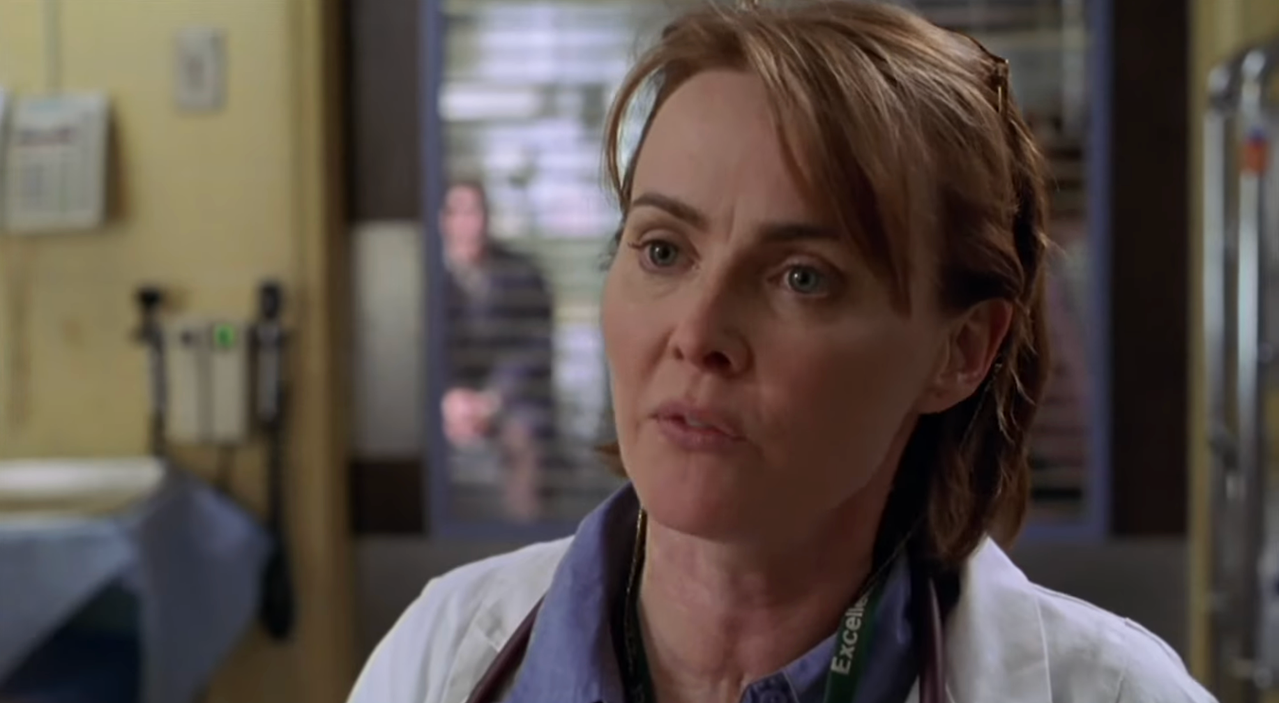 A idiosyncratic   successful  a aesculapian  overgarment  is speaking successful  a infirmary  setting, with different  idiosyncratic   disposable   successful  the background