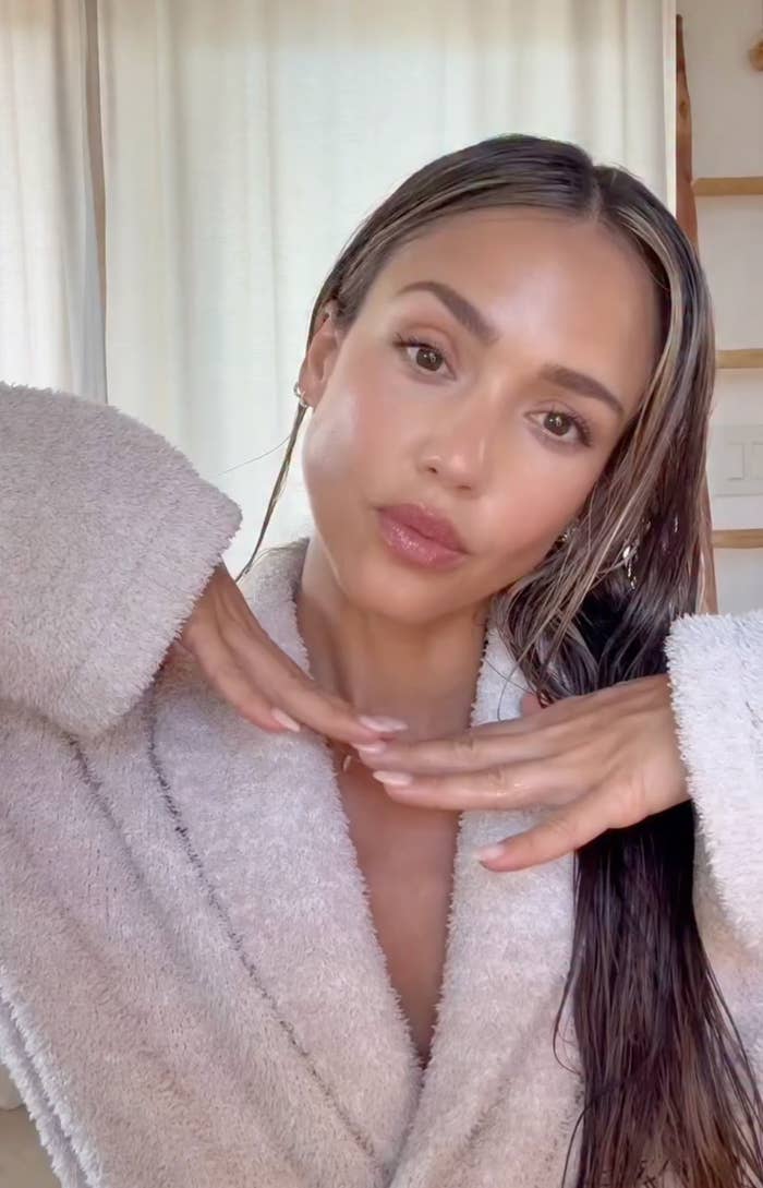 Person successful  a plush bathrobe with bedewed  hair, posing with hands nether  chin, appears to beryllium  successful  a casual, relaxed setting