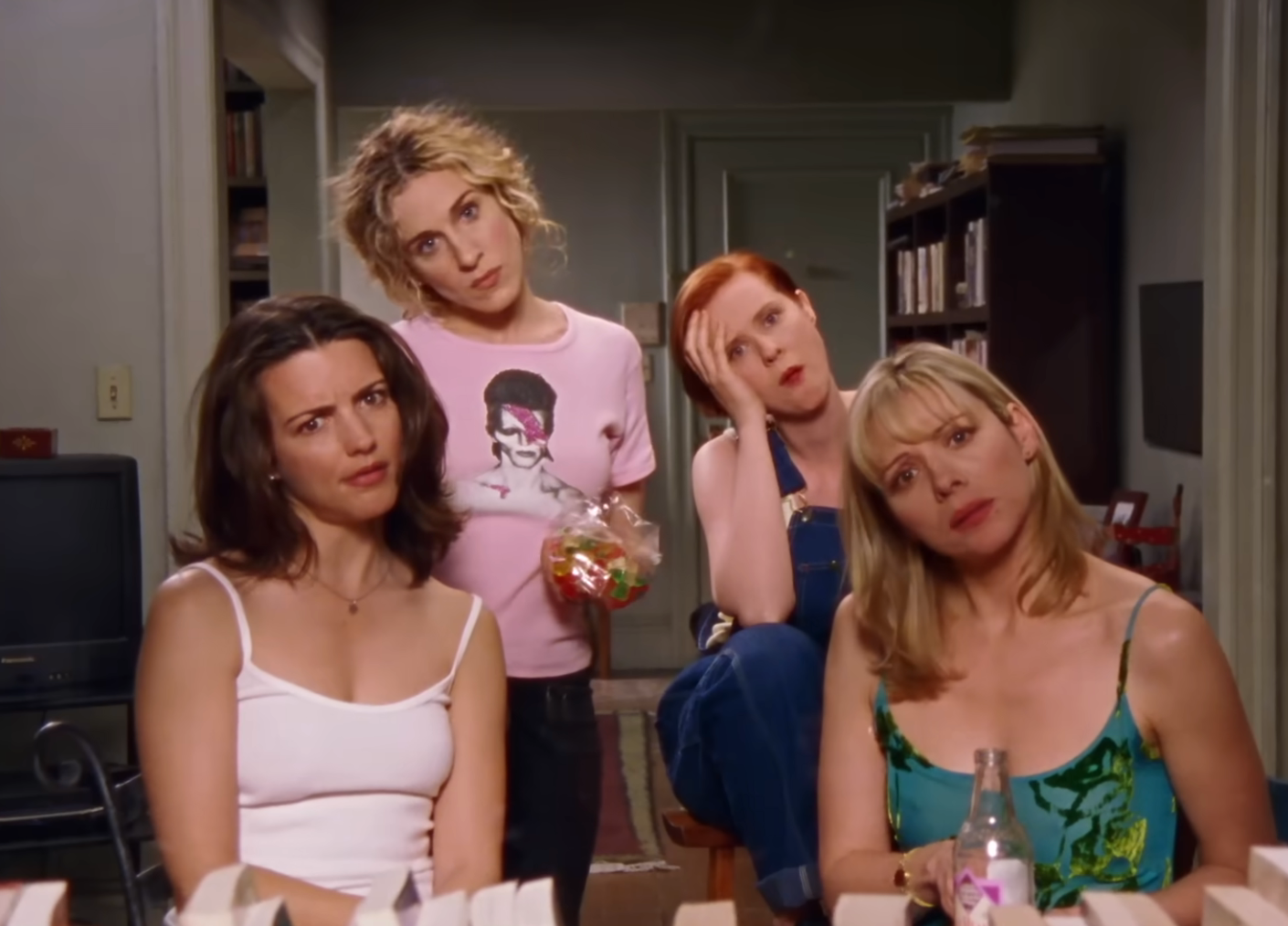 Four women from a TV amusement   country   look   puzzled portion    sitting and standing, showcasing aboriginal  2000s municipality  manner  successful  a casual setting