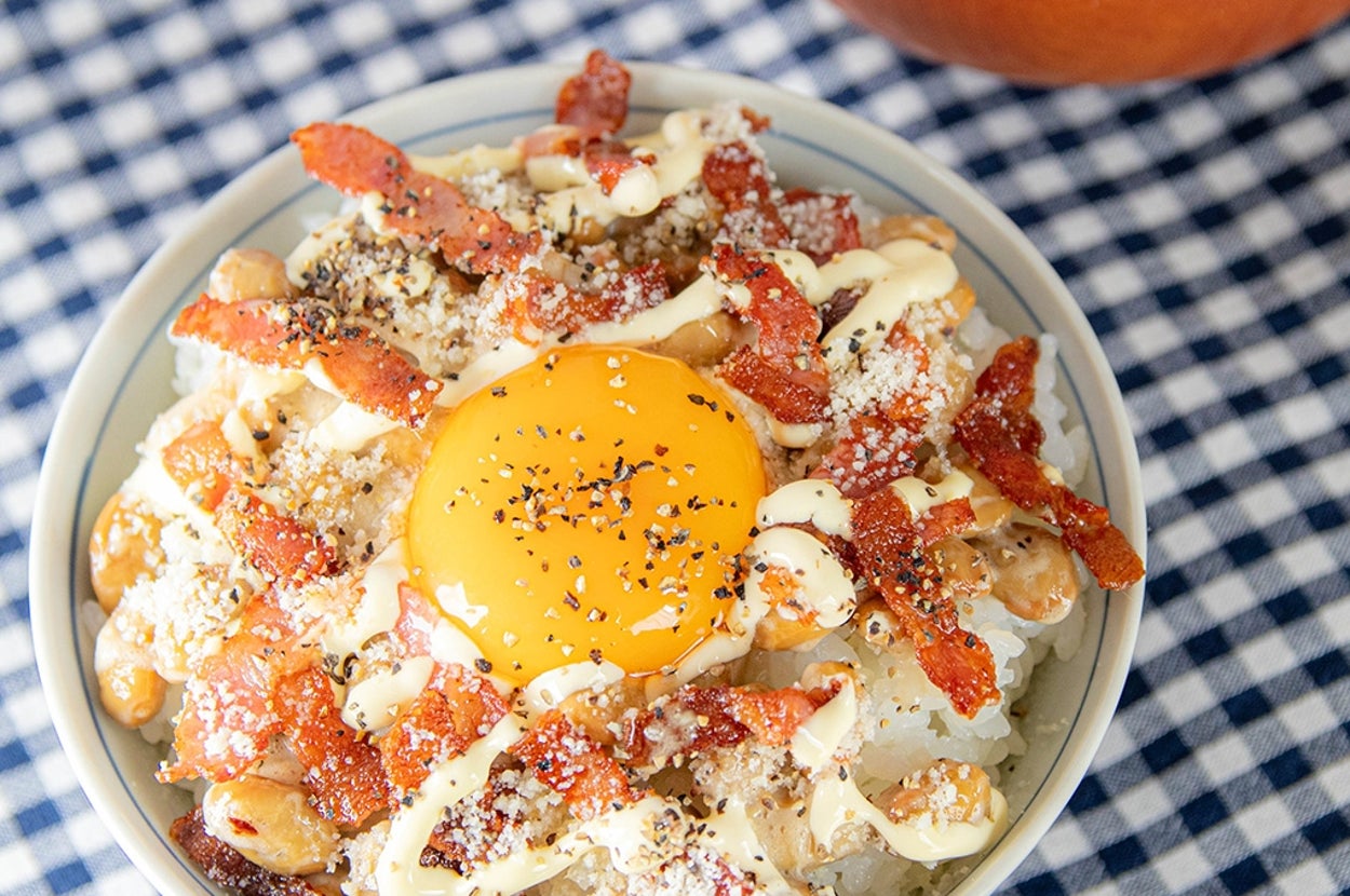 卵黄、ベーコン、マヨネーズ、納豆が載ったご飯の横に味噌汁。