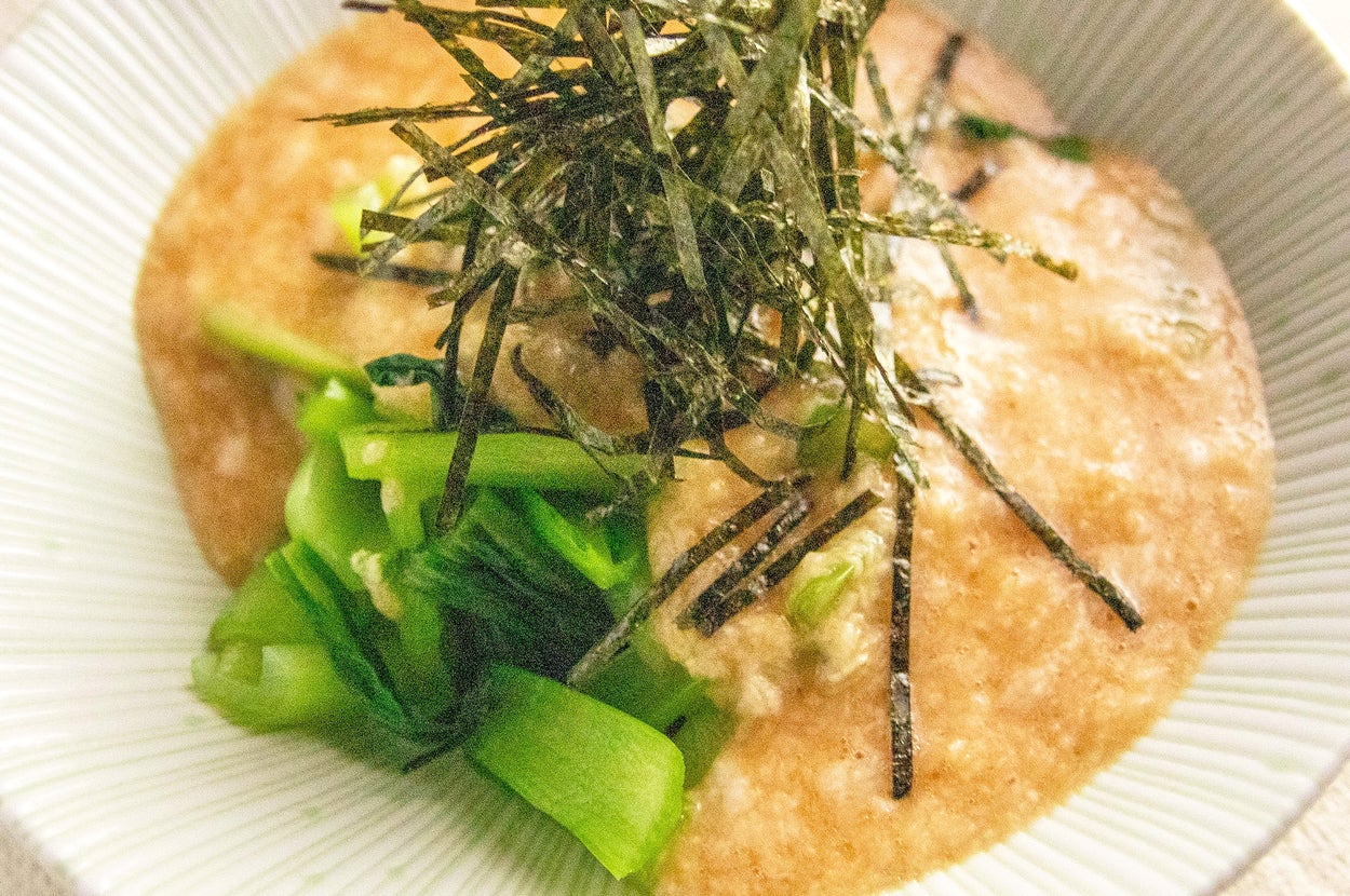 山芋ご飯の上に刻み海苔と青菜が添えられた料理。
