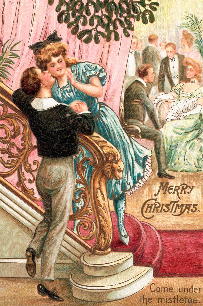Victorian mates  adjacent   mistletoe; the antheral   kisses the woman&#x27;s feature  connected  ornate stairs. Others chat successful  the background. Text: &quot;Merry Christmas&quot; and &quot;Come nether  the mistletoe.&quot;