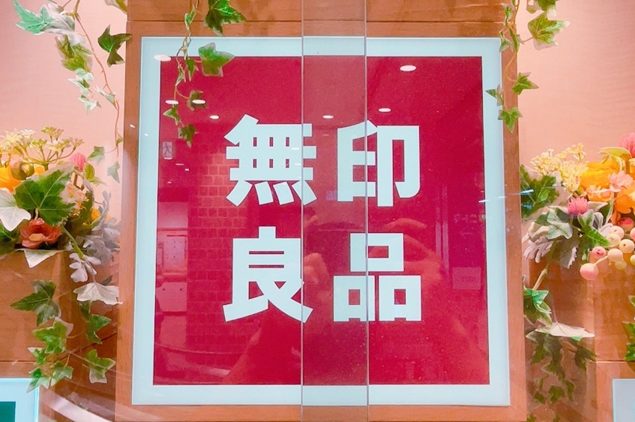 店内の装飾として展示されている「無印良品」の看板と植物。