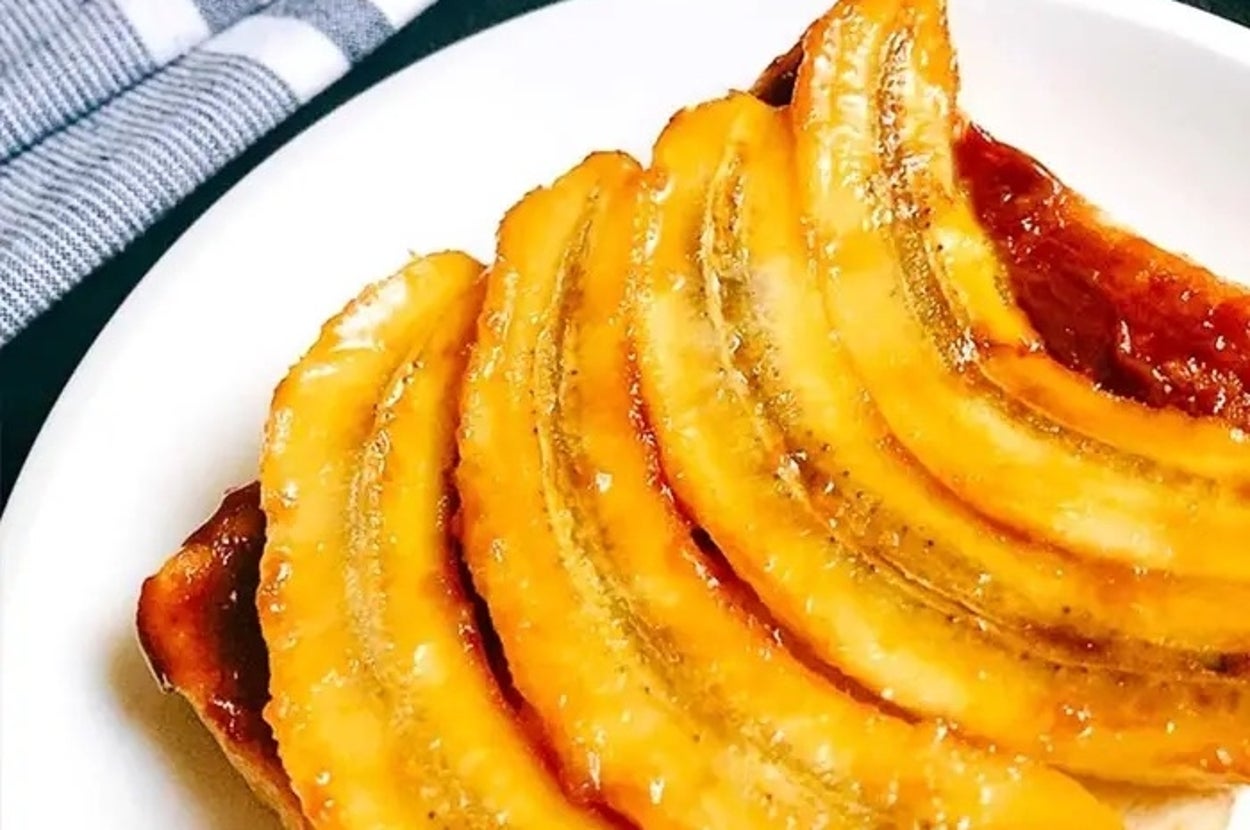 トーストの上にスライスされたバナナとジャムがのっています。おしゃれな朝食の一例です。