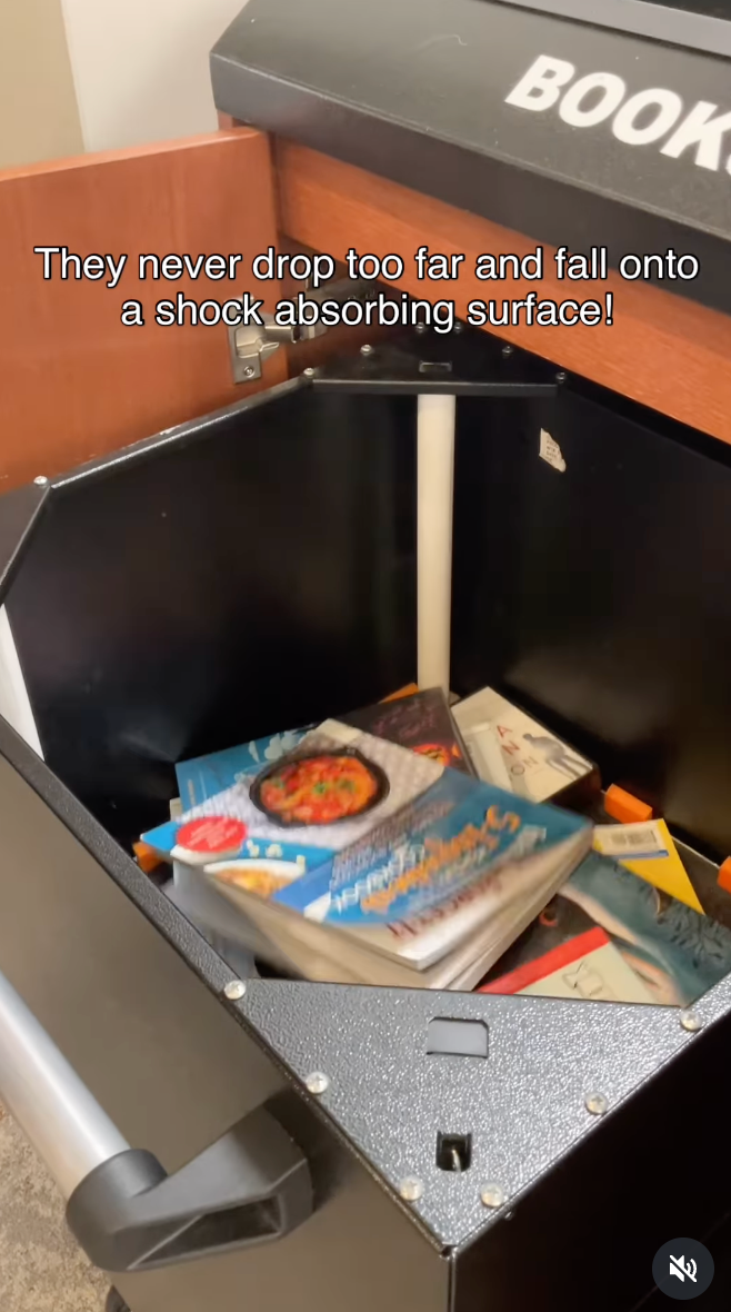 Books driblet  mildly  onto a cushioned aboveground  successful  a publication  instrumentality    bin