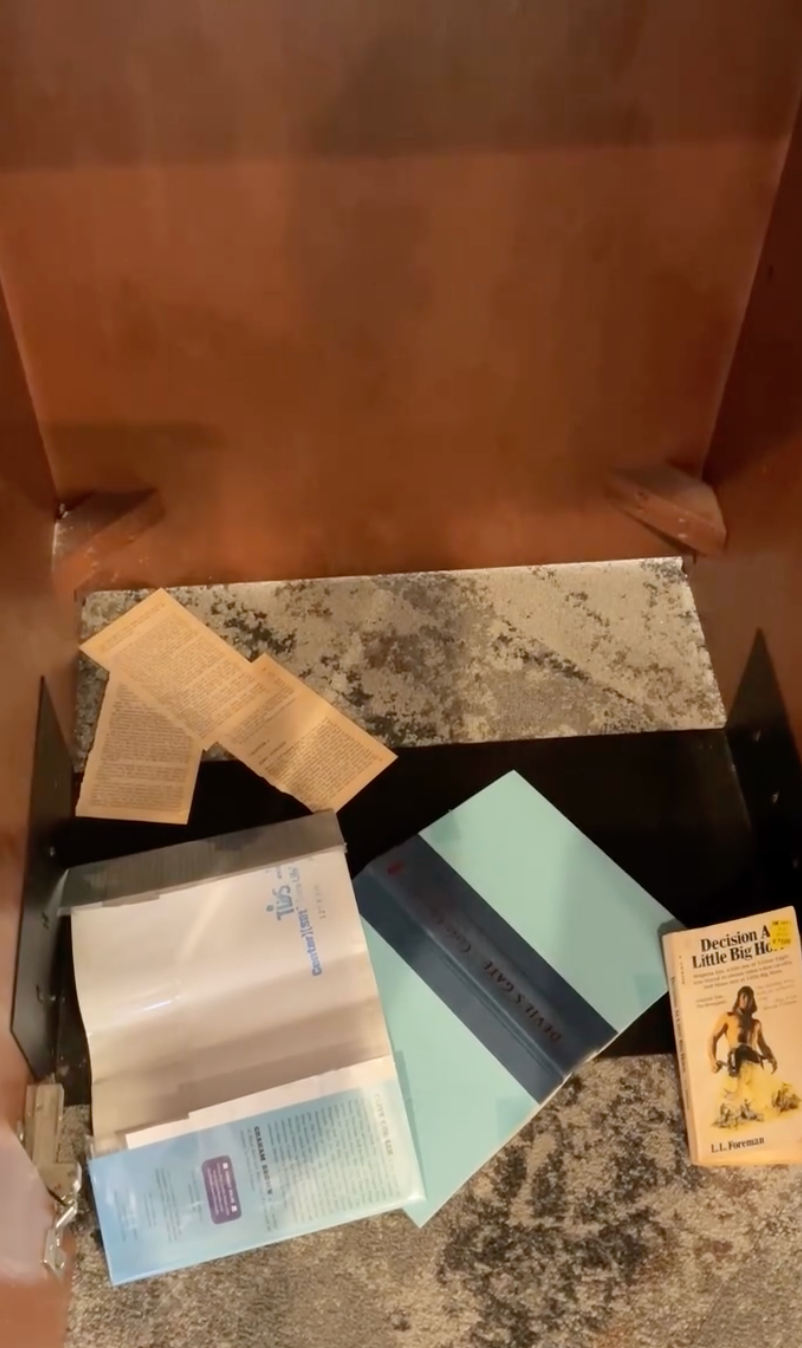 Books and papers connected  a small, carpeted shelf, including &quot;Decision astatine  Little Big Horn&quot; by J.L. Penrose