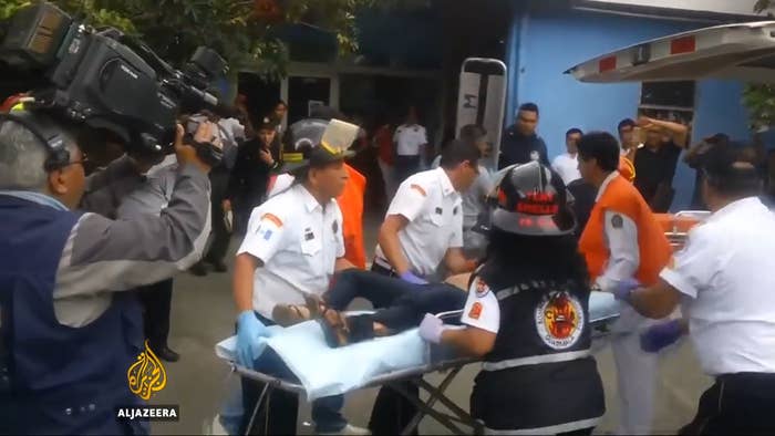 Emergency responders assistance   an injured idiosyncratic   connected  a stretcher extracurricular  a building, with media capturing the scene