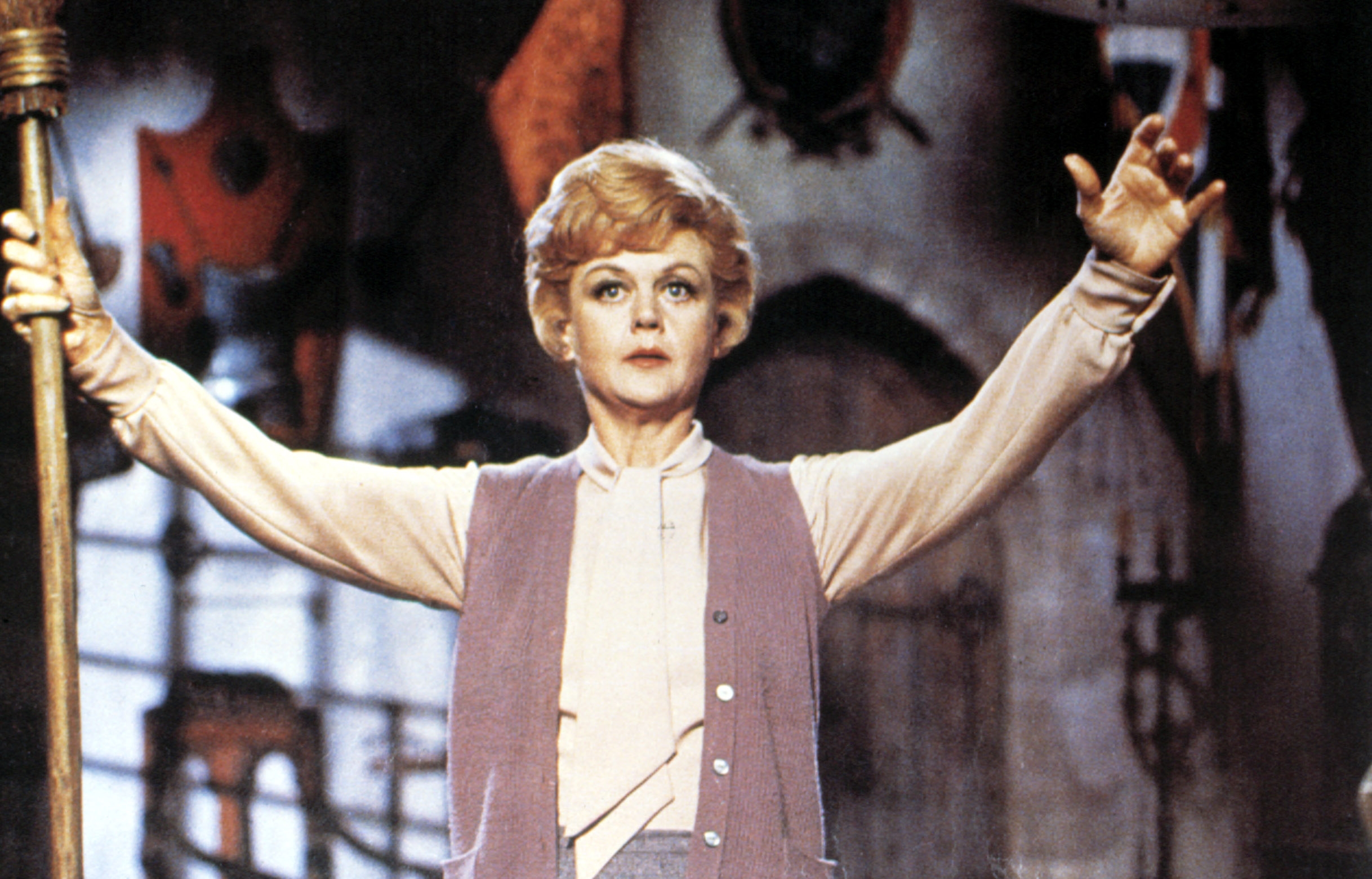 Person successful  a play  mounting  holds a unit   with arms raised dramatically, wearing a agelong  vest implicit    a blouse