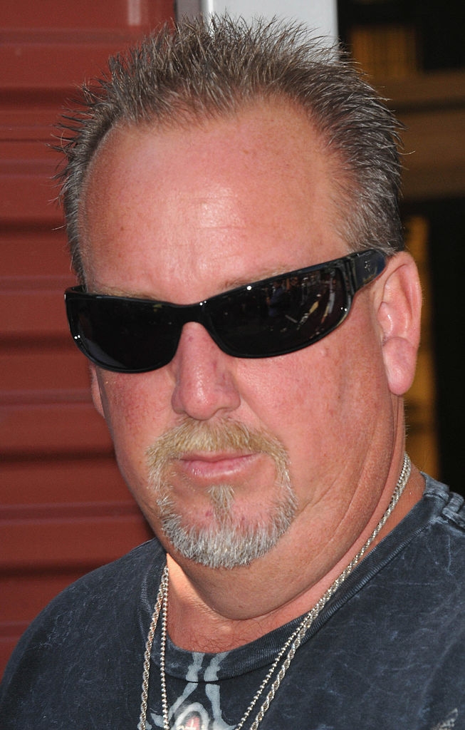 A idiosyncratic with abbreviated hairsbreadth and a goatee wearing acheronian sunglasses and a casual shirt, looking straight astatine the camera