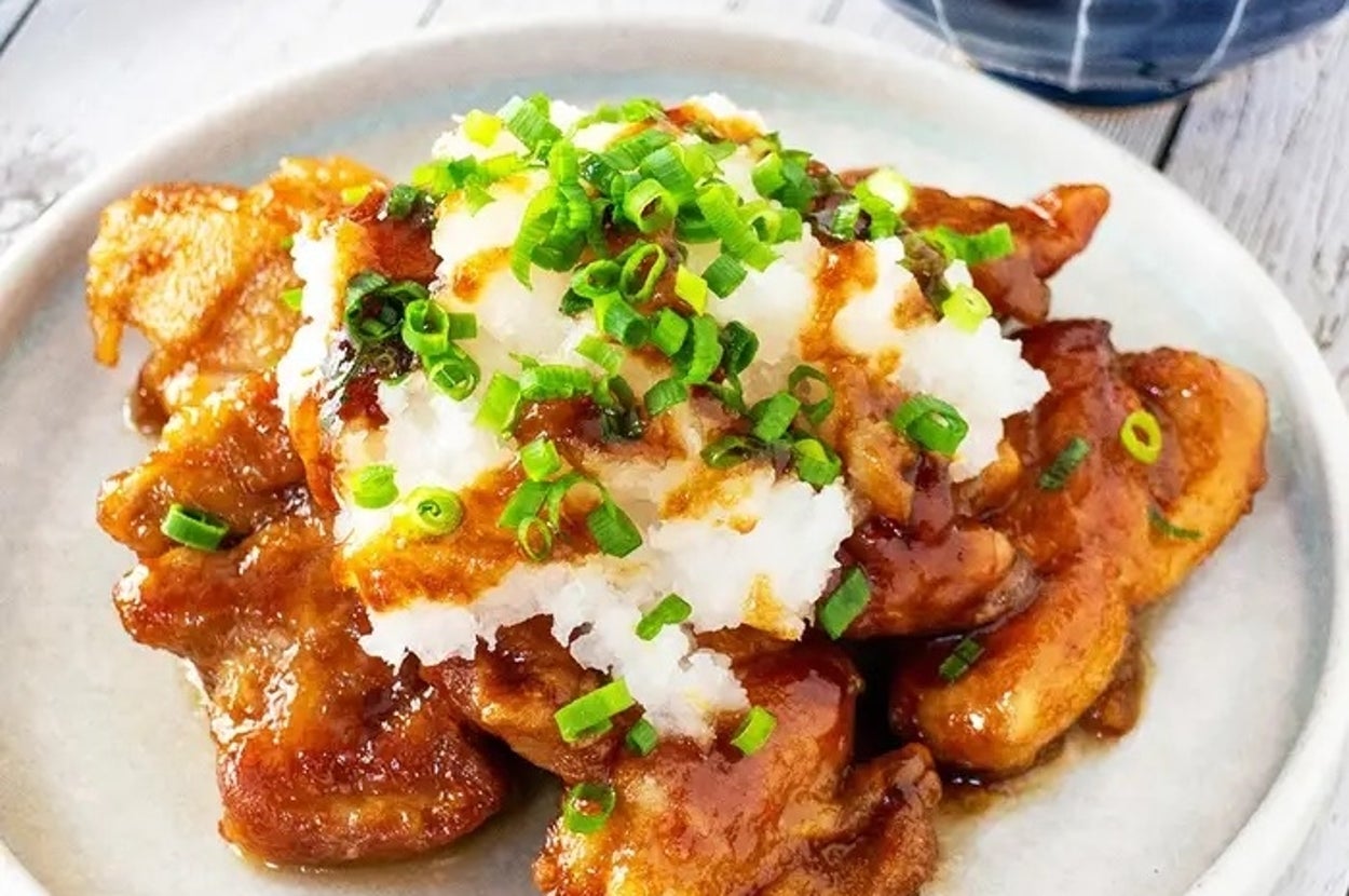 おろしポン酢チキンの皿盛り。刻みネギとおろしがトッピングされ、美味しそうな料理が食欲をそそる。背景にご飯のボウル。