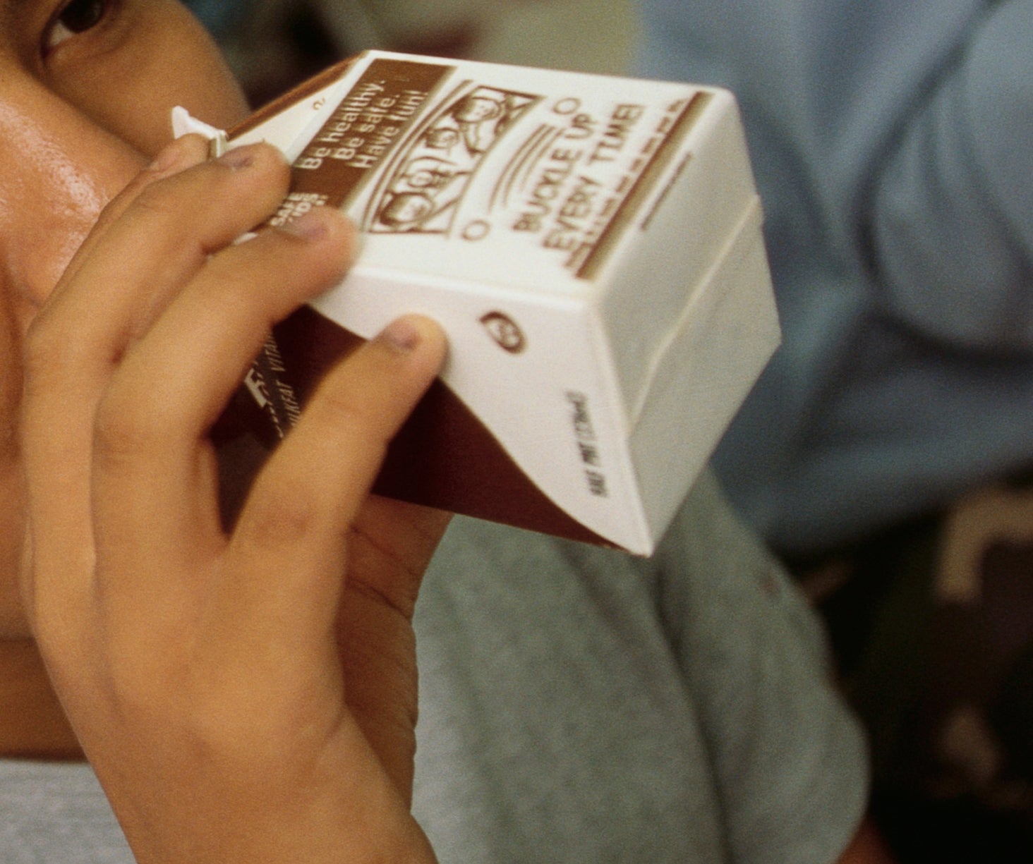 A idiosyncratic drinks from a beverage carton successful a cafeteria setting