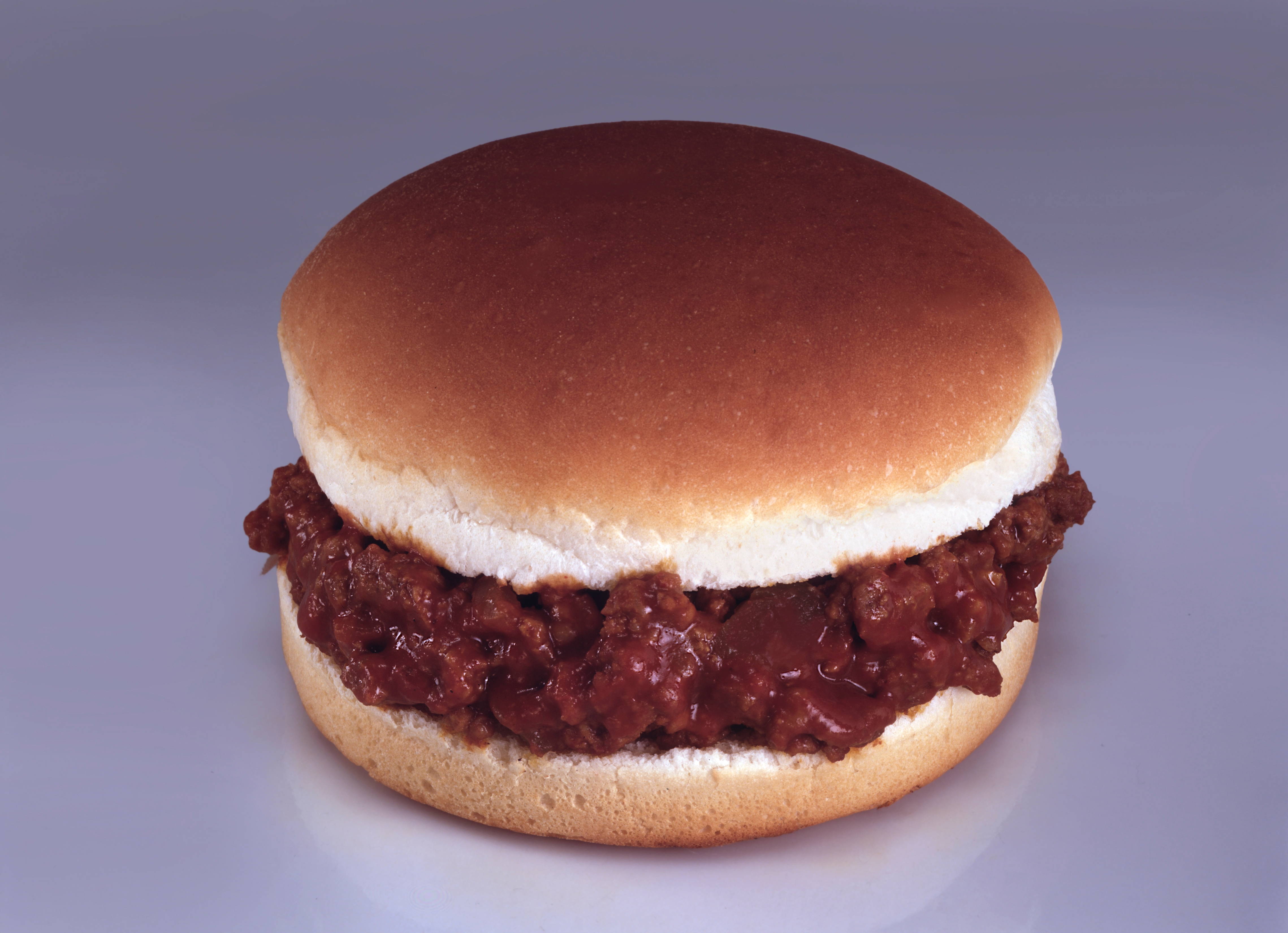 A Sloppy Joe sandwich with a bun filled with seasoned crushed meat, commonly associated with casual American dining