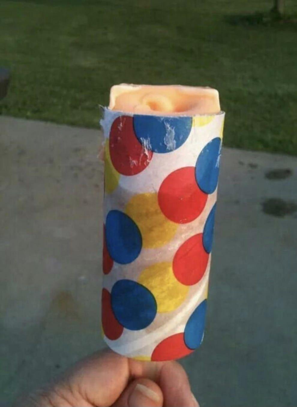 Hand holding a propulsion popular with colorful polka dot wrapper successful an outdoor setting