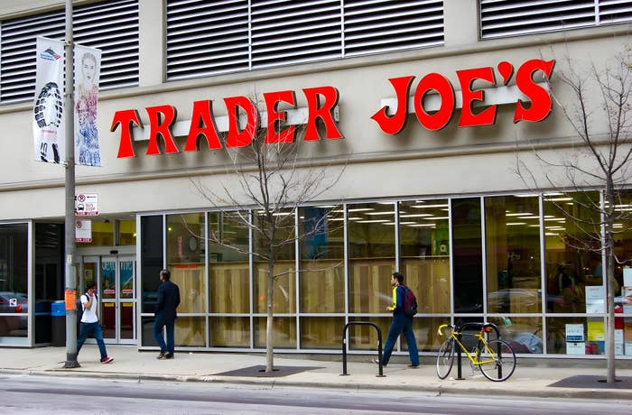People walking into a Trader Joe&#x27;s store with a bicycle parked nearby