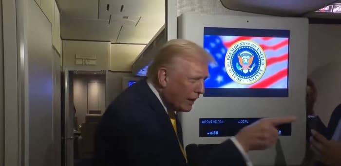 Person successful  a suit   connected  a plane, gesturing adjacent   a surface  displaying a seal with a emblem  background