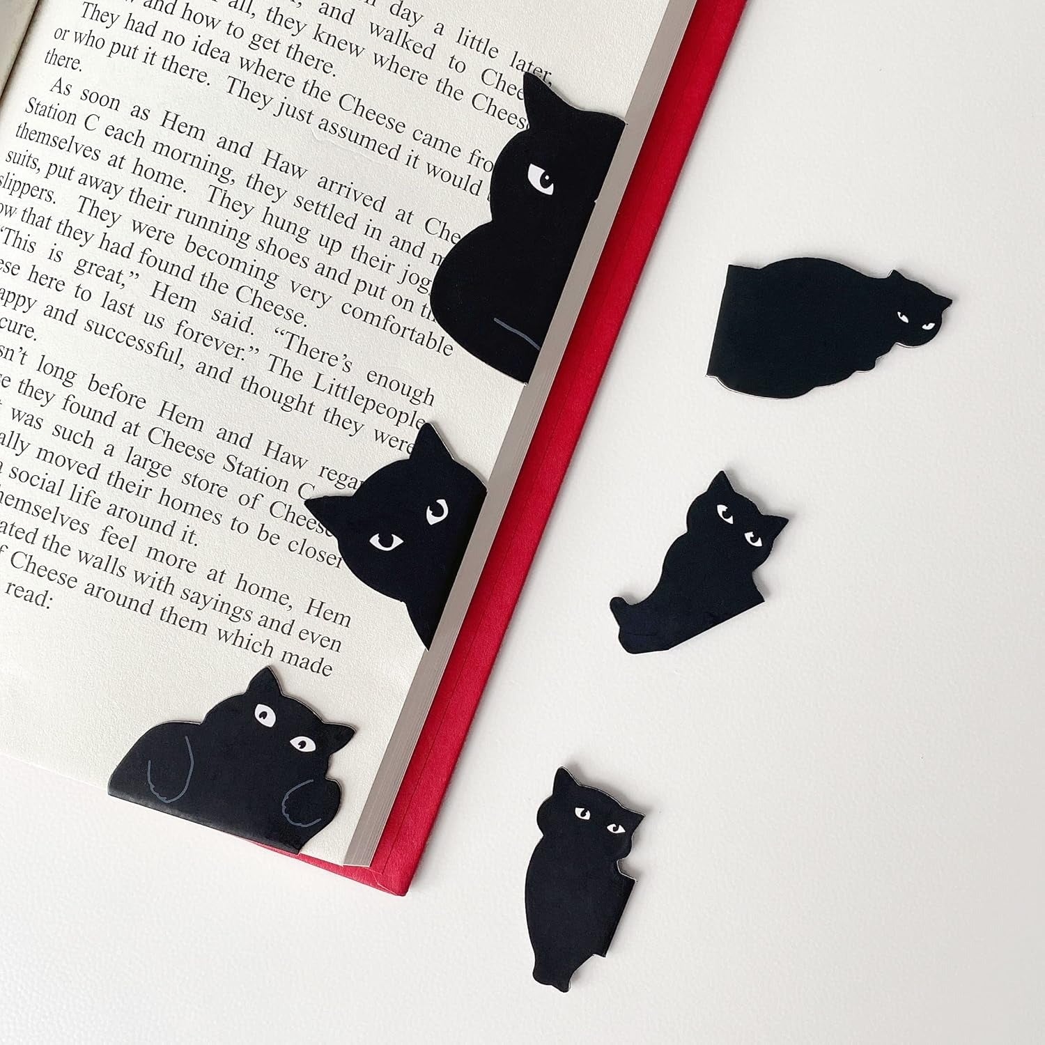 Open publication  with achromatic  cat-shaped bookmarks placed connected  pages and a achromatic  surface