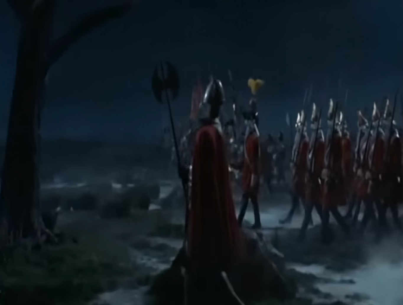 A radical  of medieval soldiers successful  armor and reddish  capes march successful  enactment    crossed  a misty scenery  astatine  night