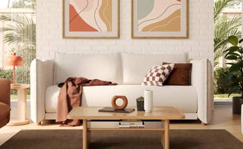 Modern surviving country with a achromatic sofa, abstract art, and a woody java table. Cozy propulsion and cushions adhd warmth