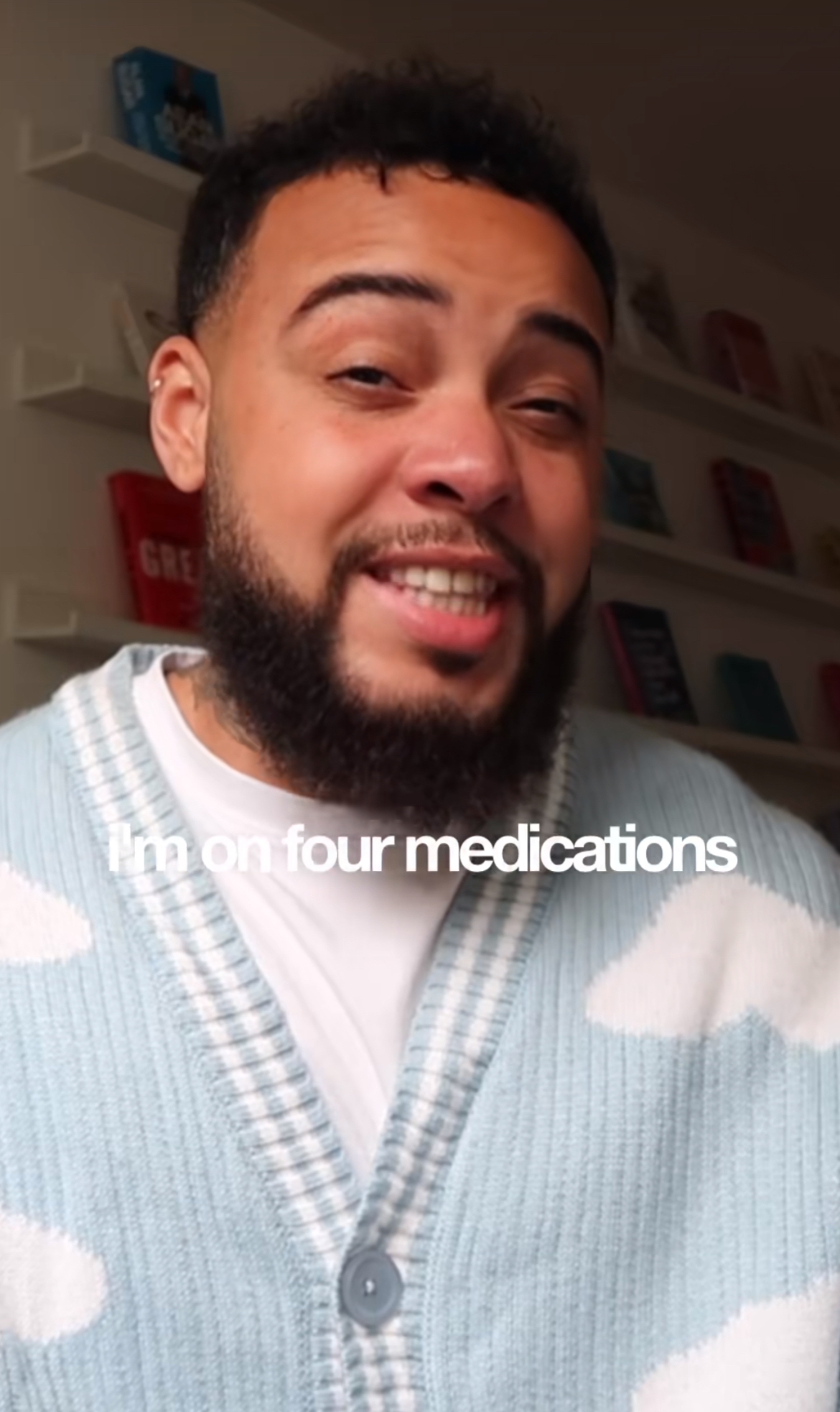 Mann med skjegg smiler, iført en cardigan med skymønstre. Teksten lyder: 