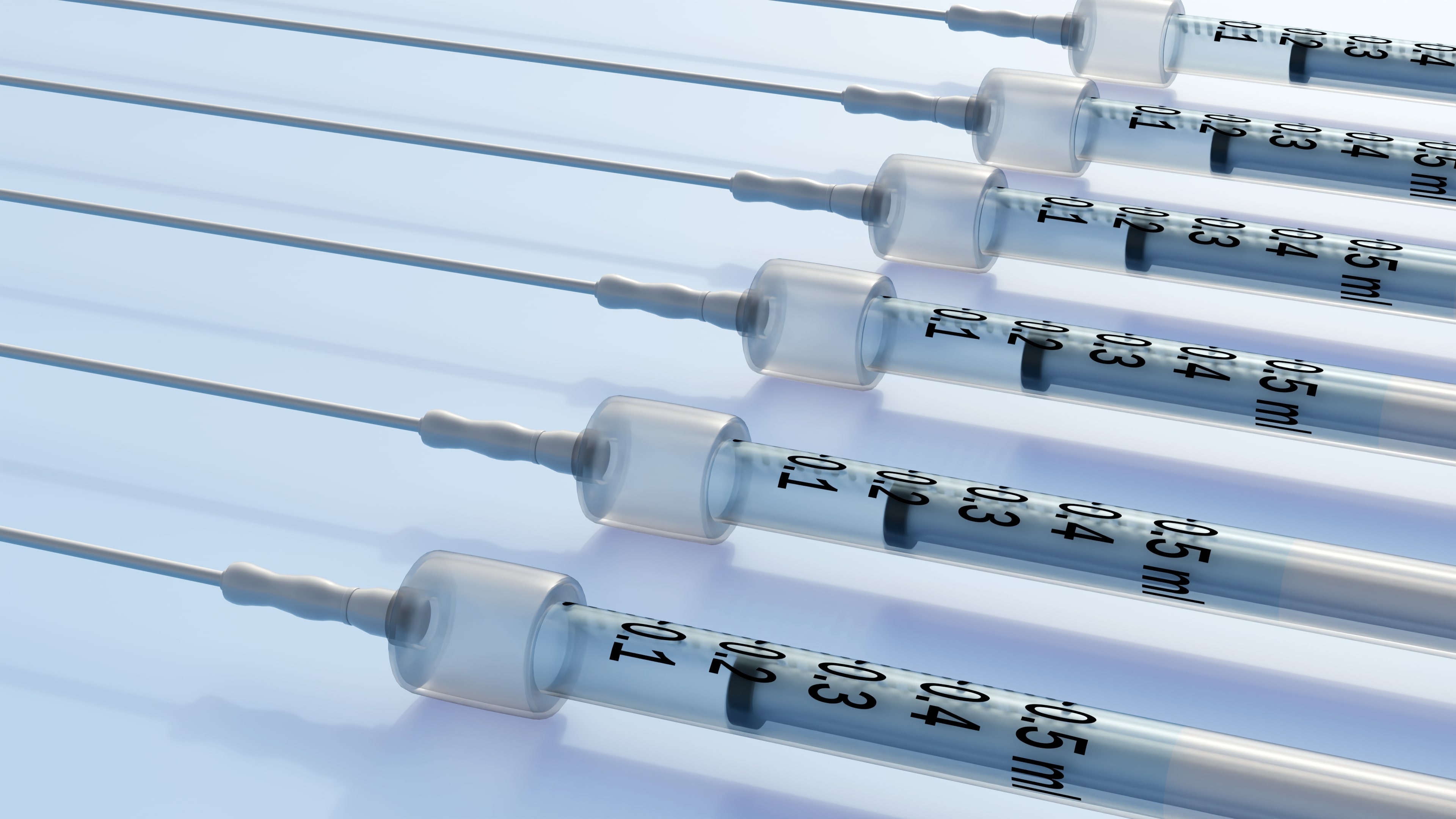 Flere innrettede sprøyter med målemarkeringer, liggende på en flat overflate