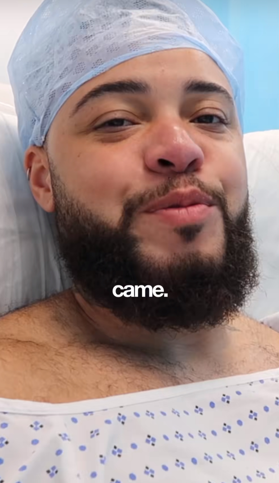 Person som ligger i sykehusseng med kirurgisk hette, iført kjole med blått mønster. Teksten på bildet lyder 