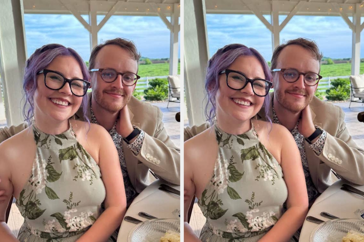 Two people smiling at a table outdoors. The woman wears a floral halter dress, and the man has glasses and a beige blazer