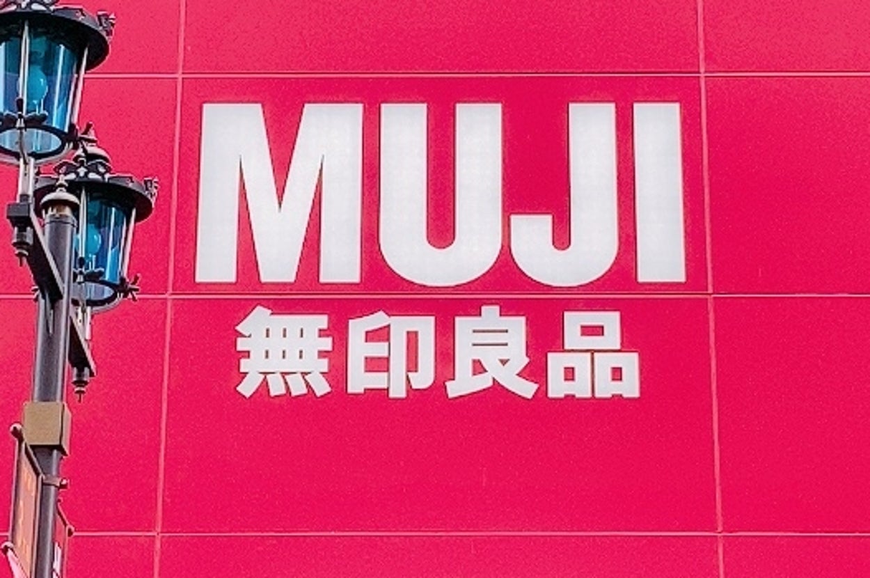無印良品店舗の正面外観。大きな看板に「MUJI 無印良品」と表示されています。店舗の入り口に向かって開かれています。