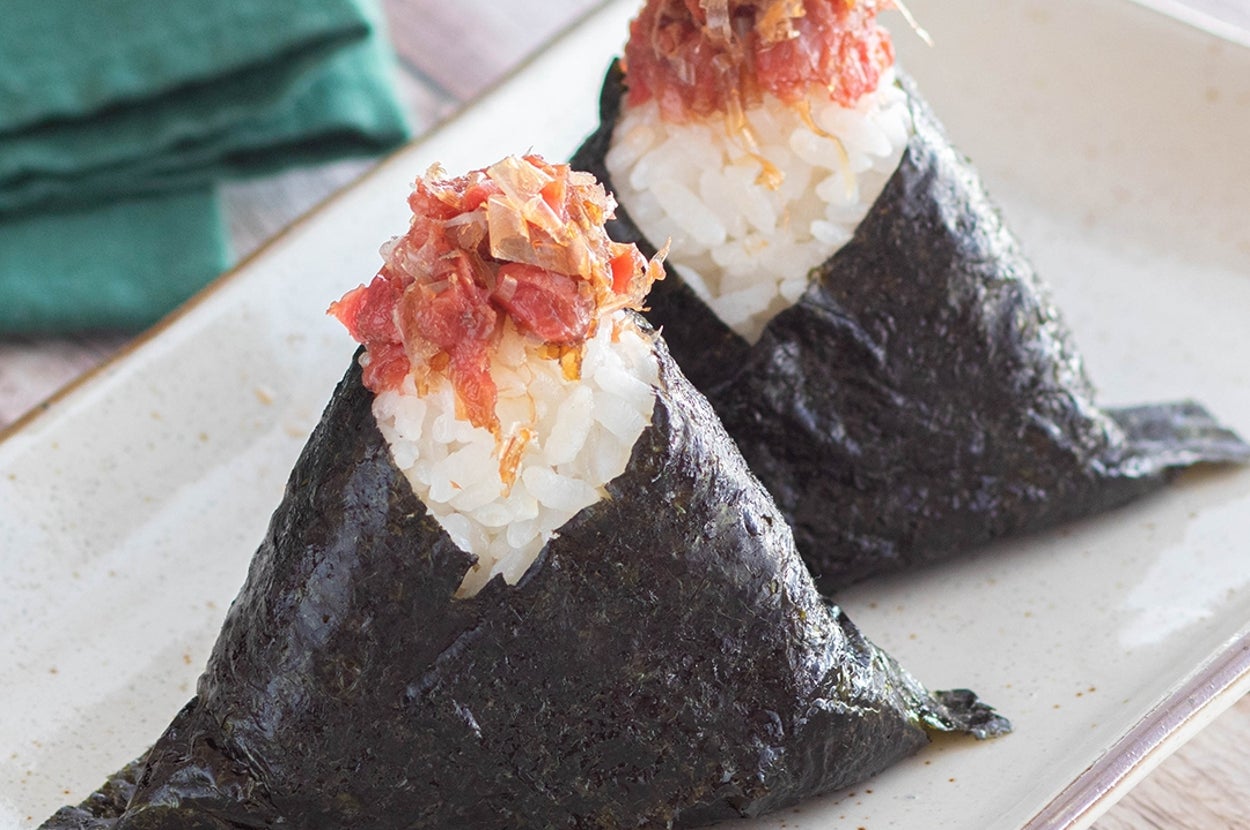 お皿に盛られた2つのオニギリ。海苔で巻かれたご飯に具がのせられています。