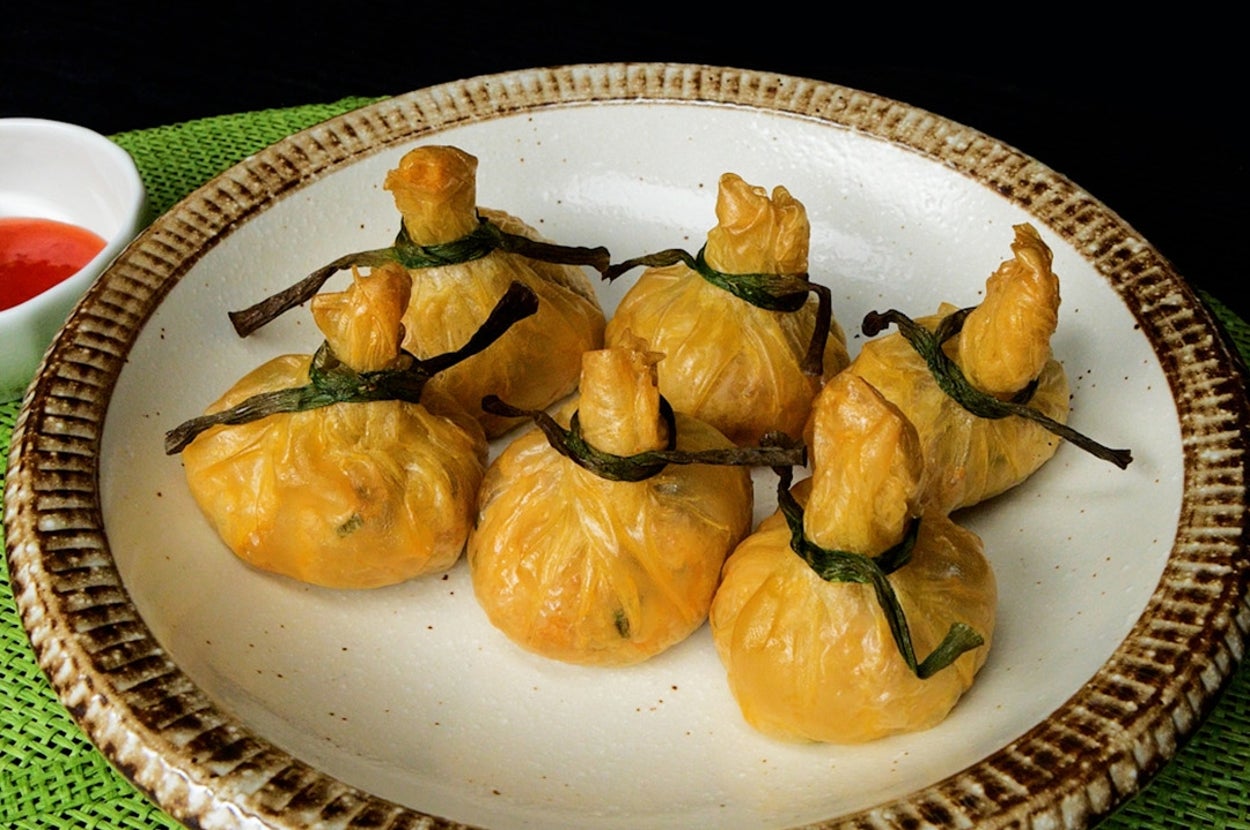 皿に盛られた包み料理とソースの小皿。蓋は紐で結ばれている。