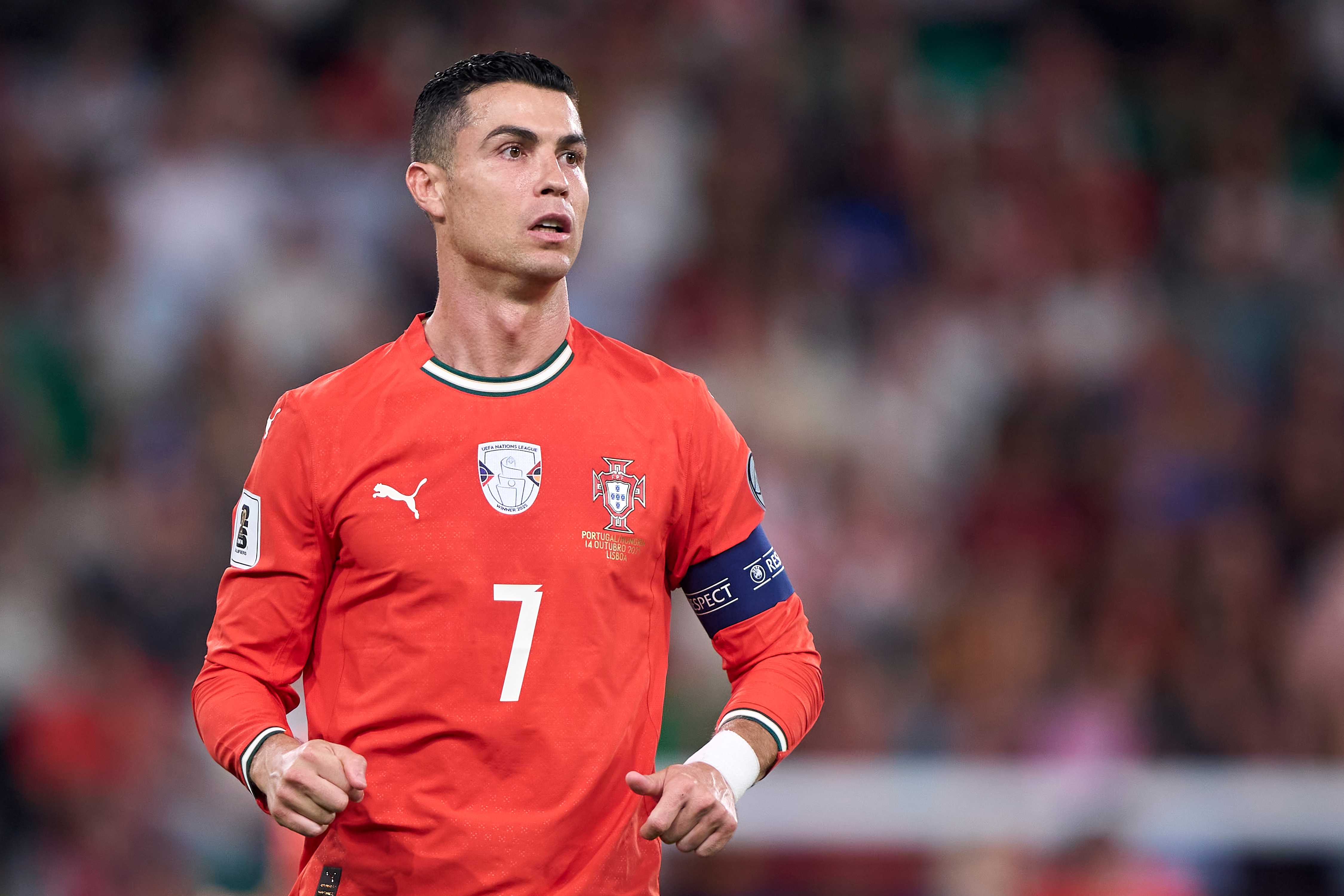 Soccer subordinate successful a reddish jersey with the fig 7 and captain's armband, connected a field