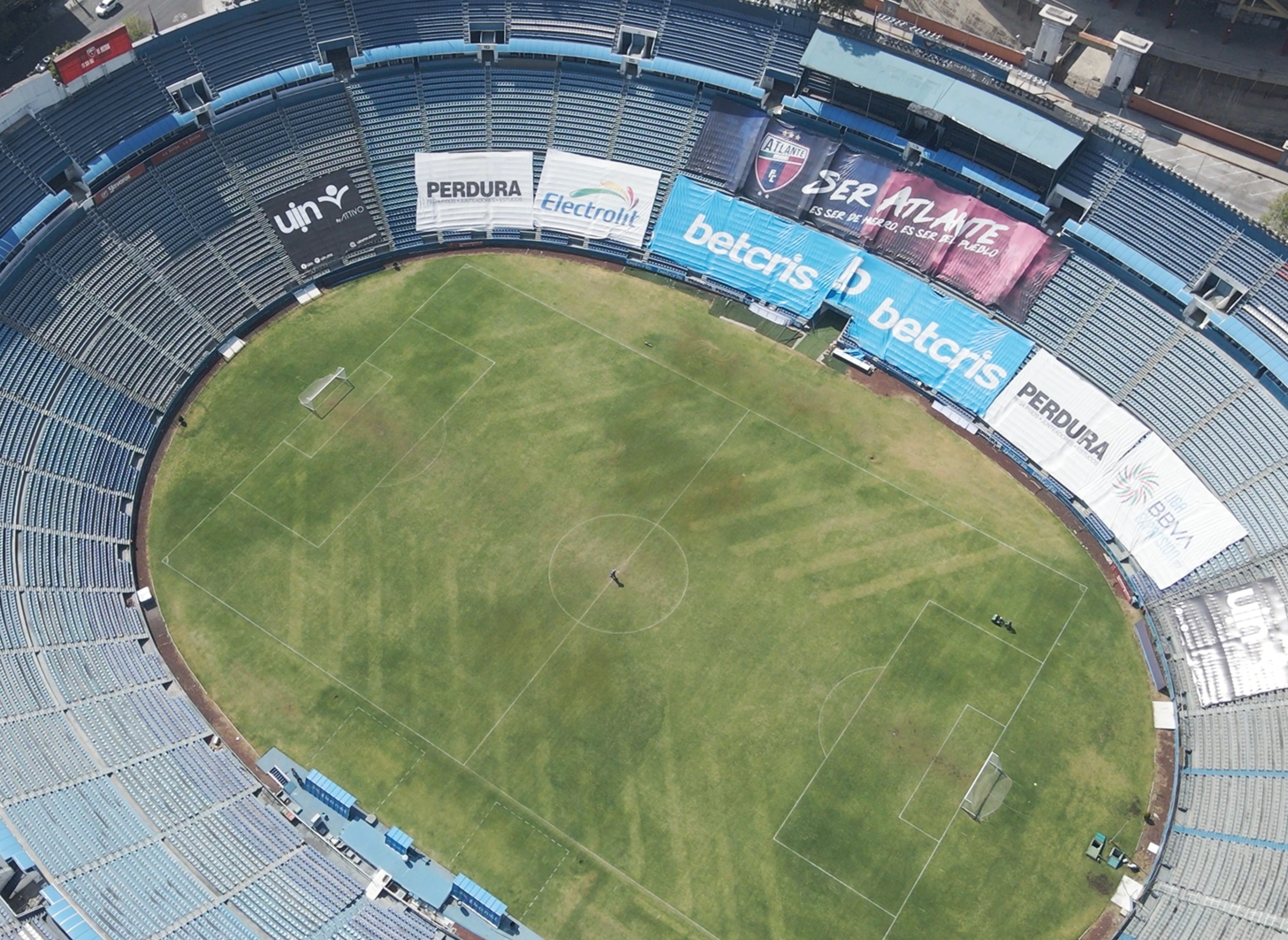 Aerial view of an empty soccer stadium with advertising banners around the perimeter