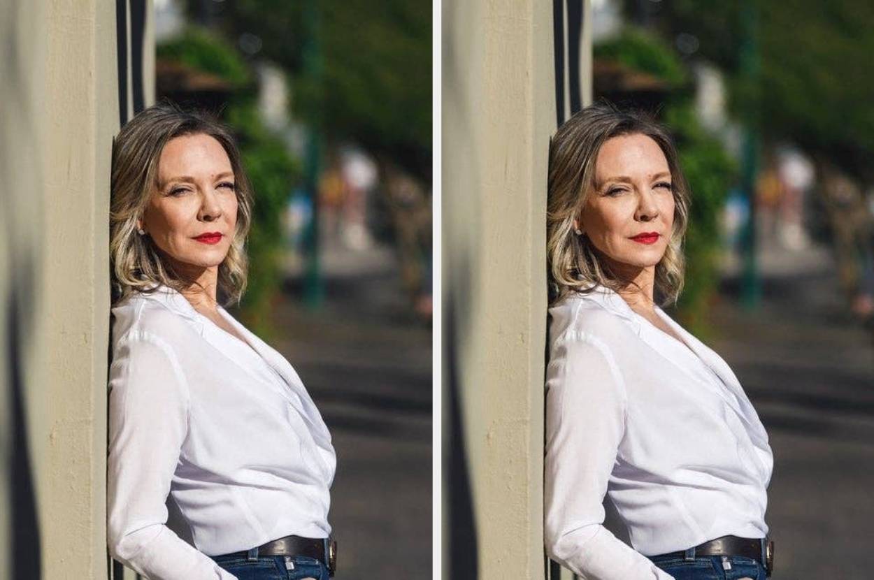 A person leans against a wall, wearing a casual white blouse and jeans, with an outdoor background