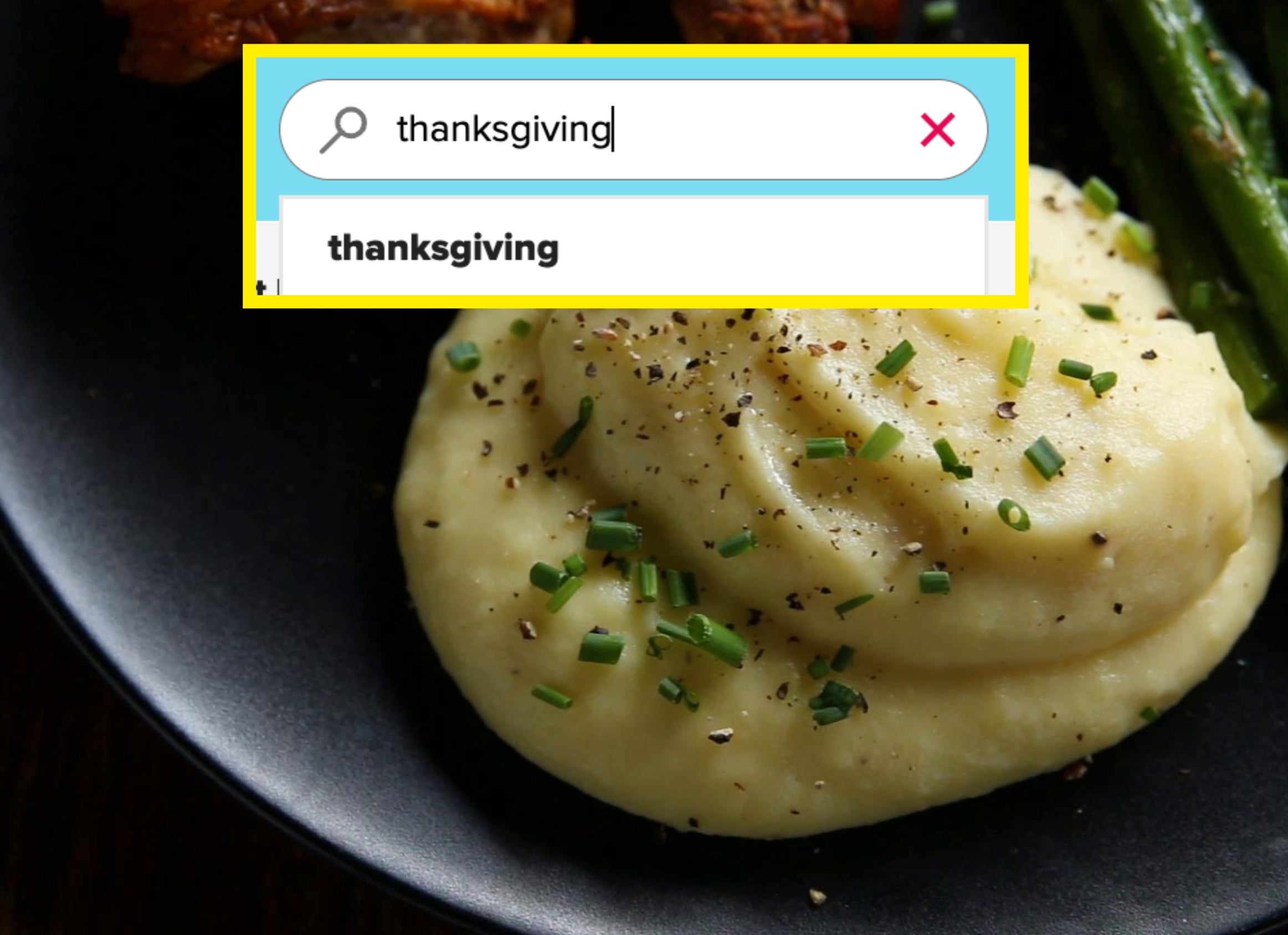 Mashed potatoes garnished with chives and black pepper on a plate, accompanied by roasted meat and asparagus