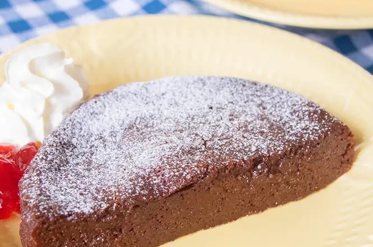 皿に乗った粉砂糖がかかった豆腐ガトーショコラとホイップクリームのデザート。