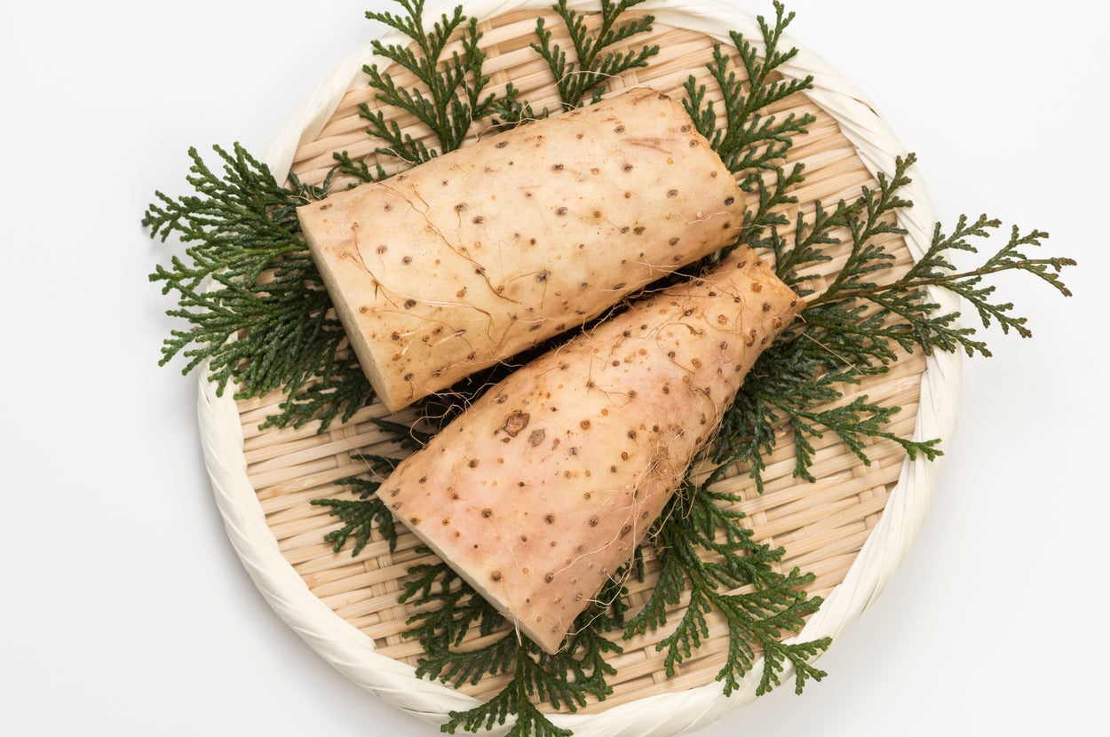 長芋が2個、編み皿に葉と一緒に盛られている画像。