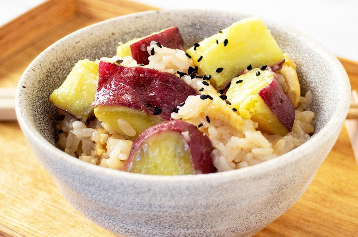 さつまいもとごまが乗った炊き込みご飯が陶器の器に盛られている。