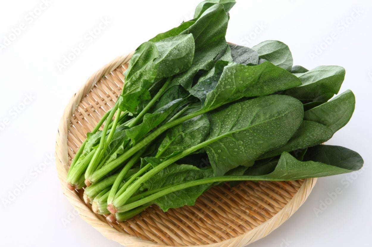 竹ざるに載せられた新鮮なホウレンソウの束。