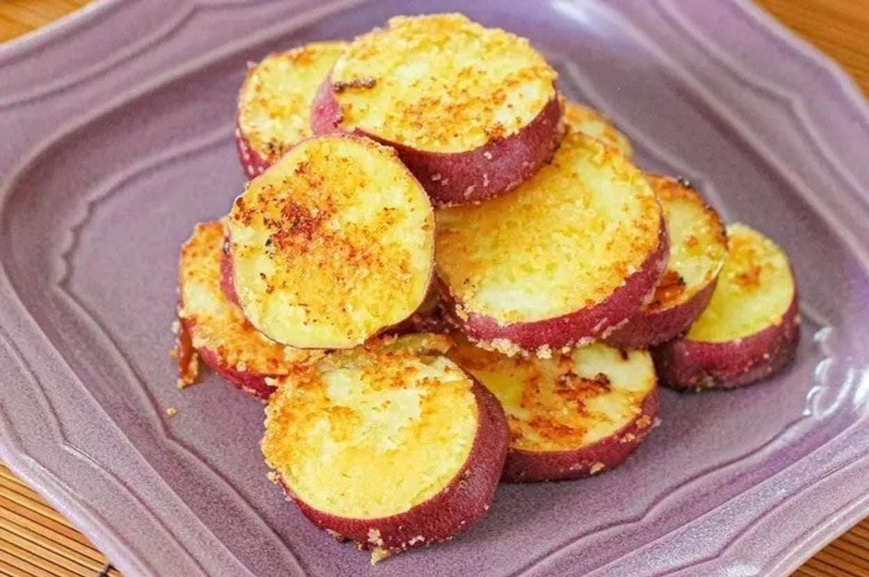 サツマイモのスライスが盛りつけられた皿。焼き色が付いた美味しそうな見た目で、テーブルに置かれている。