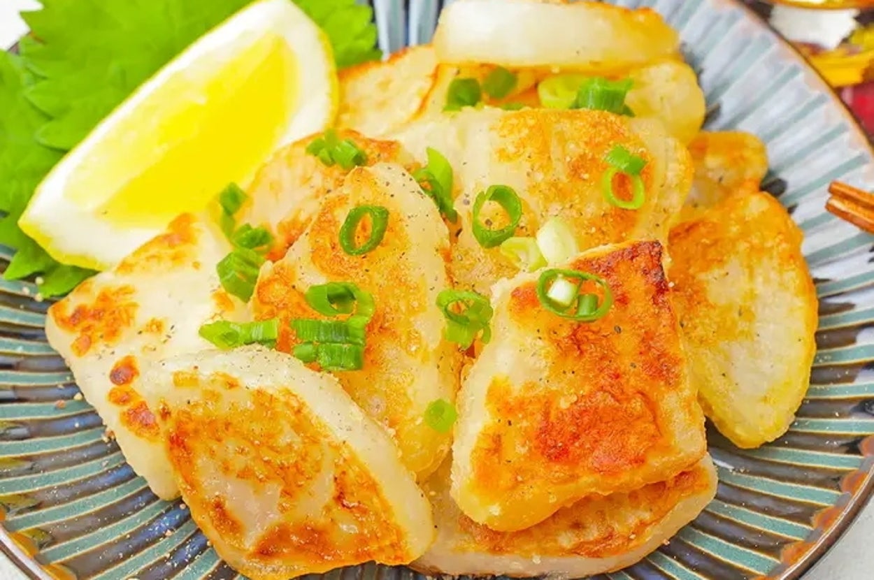 皿に盛られた大根料理。ねぎとレモンが添えられ、おいしそうに見える。