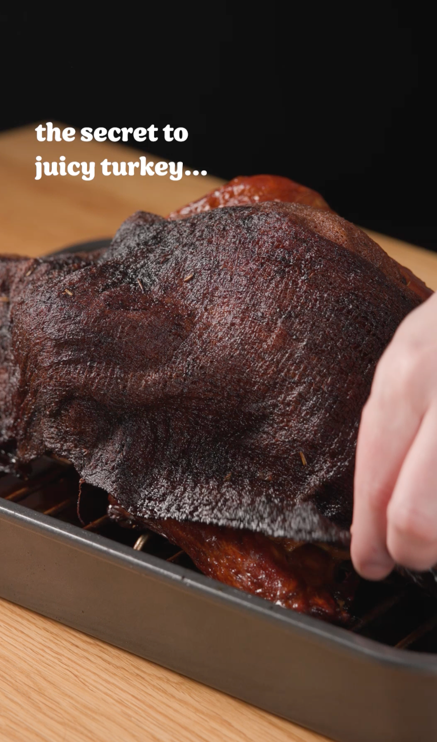 Hand lifting crispy turkey skin to reveal juicy meat; text reads, &quot;the secret to juicy turkey...&quot;