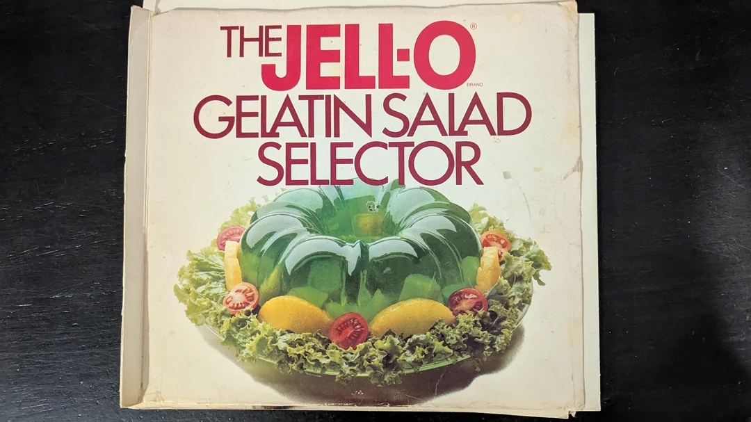 Cover of &quot;The Jell-O Gelatin Salad Selector&quot; featuring a gelatin salad on lettuce with cherry tomatoes and orange slices