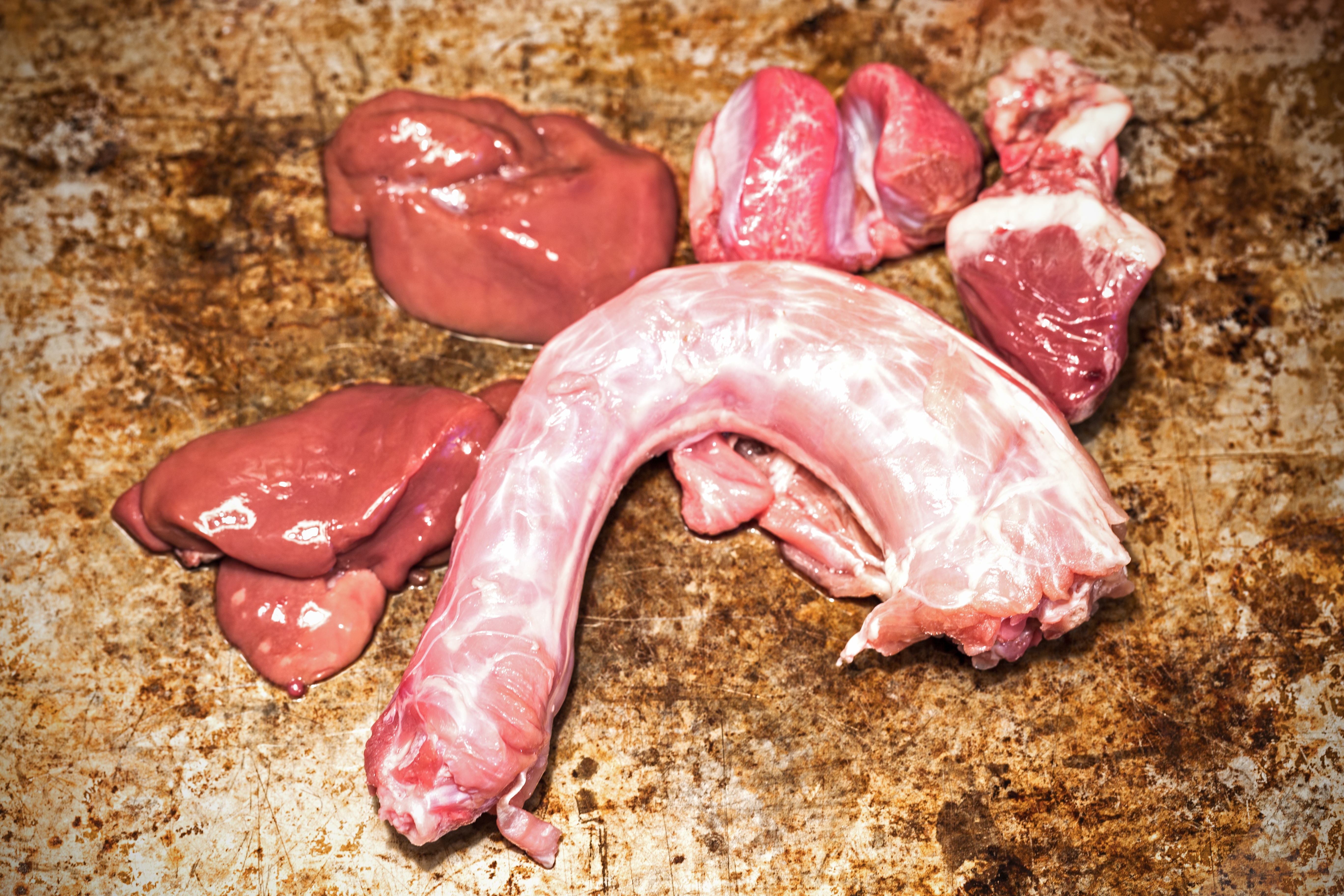 Raw turkey giblets and neck displayed on a textured surface