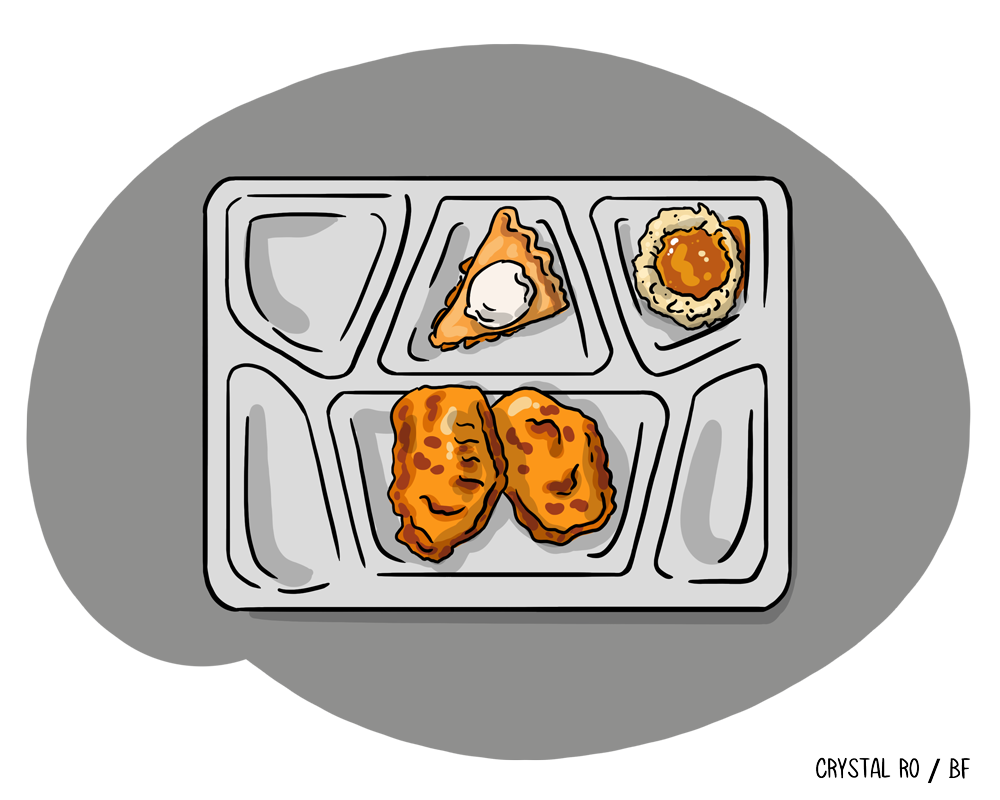 School cafeteria tray with mashed potatoes and gravy, a single ravioli, and two breaded chicken nuggets