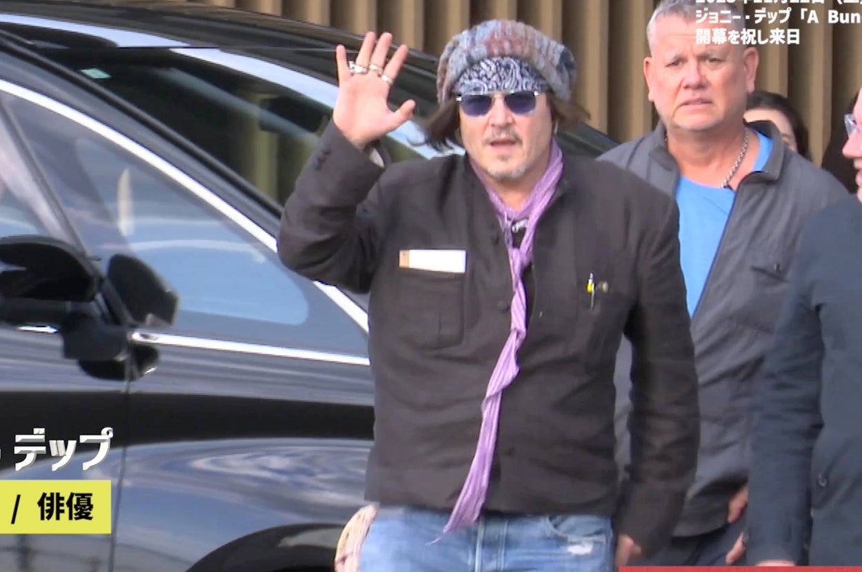羽田空港に到着後、出迎えたファンに手を振るジョニー・デップさん