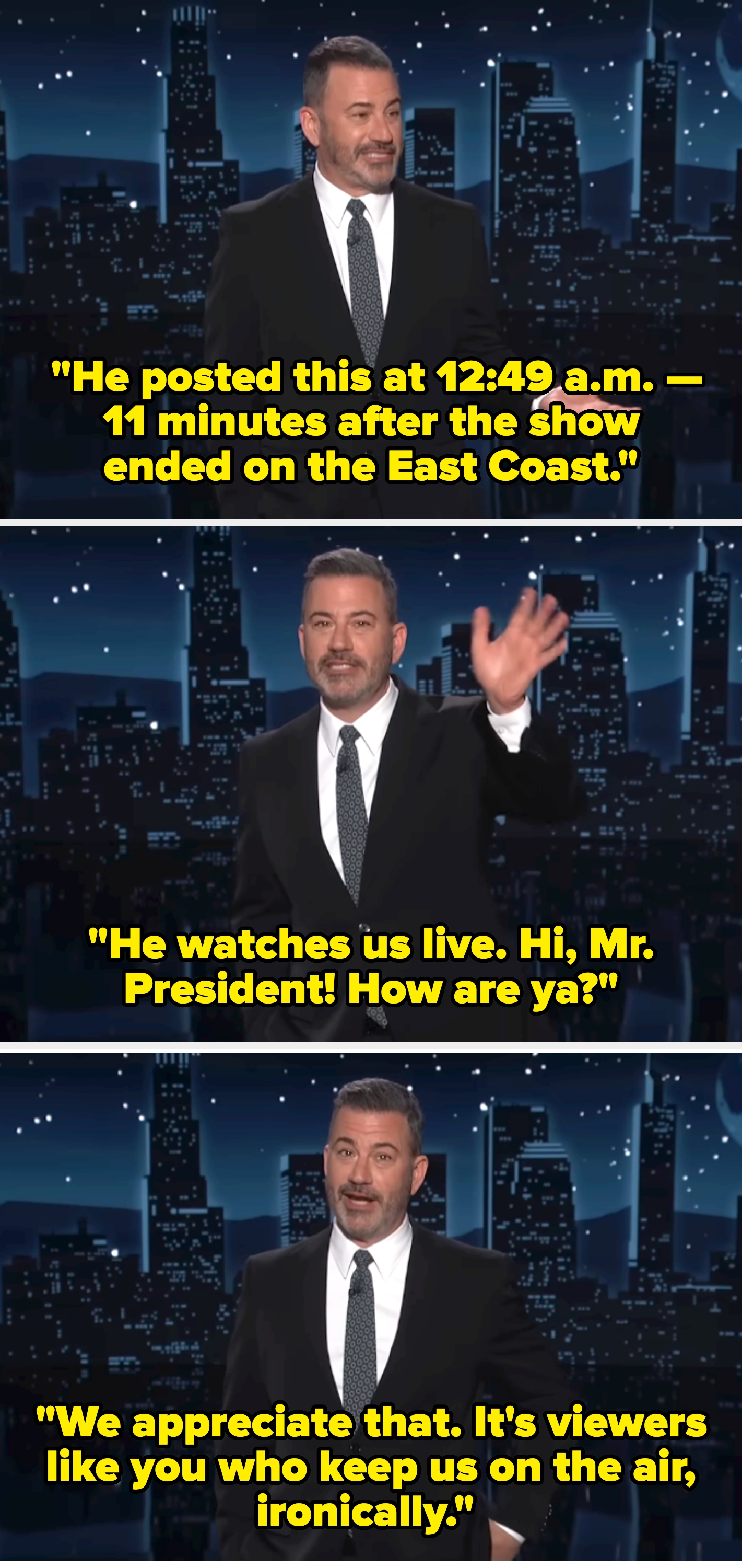 A person in a dark suit and tie stands on stage with a cityscape backdrop, smiling and gesturing with one hand