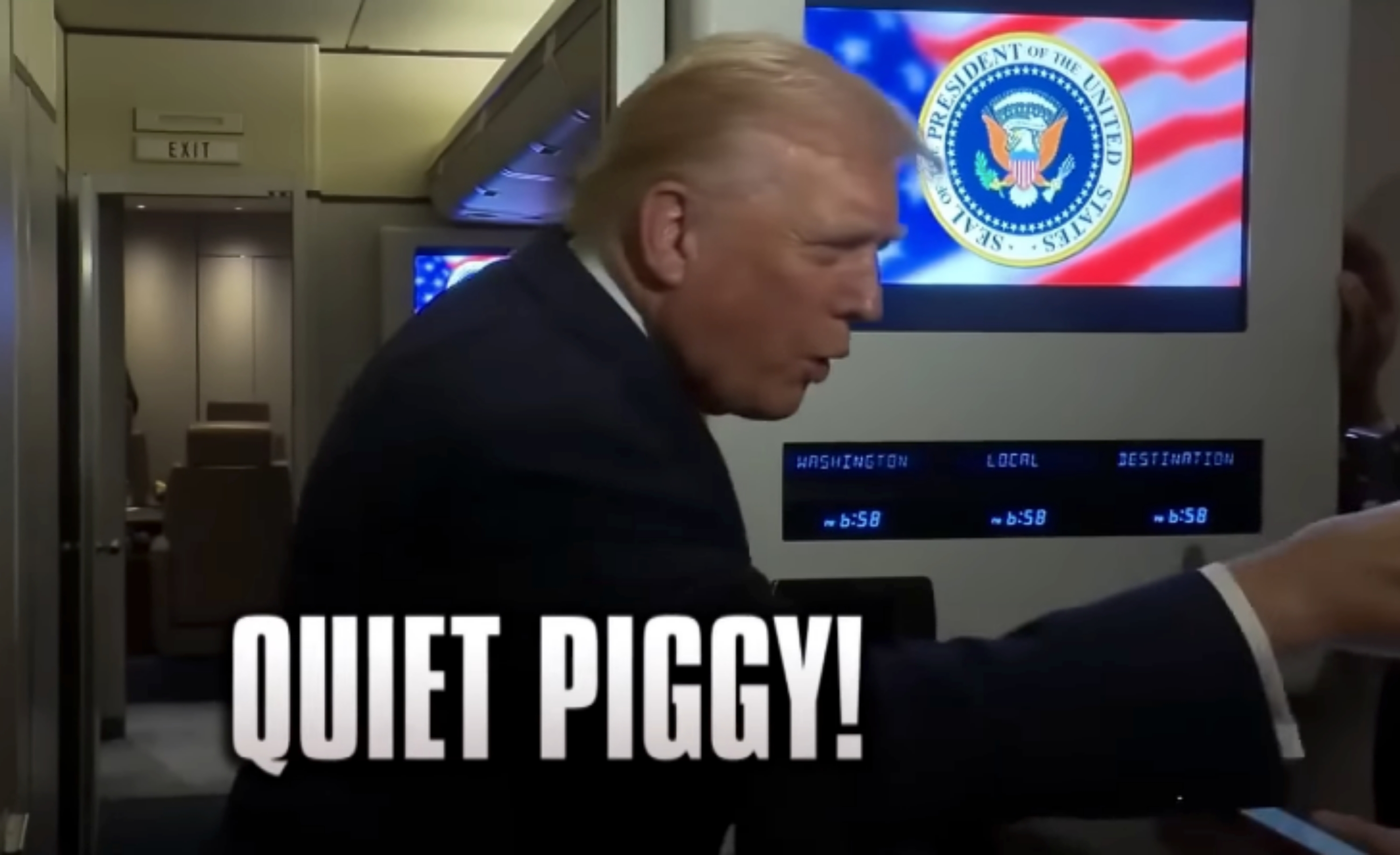 A person on an aircraft, speaking into a camera. The phrase "QUIET PIGGY!" is prominently displayed onscreen