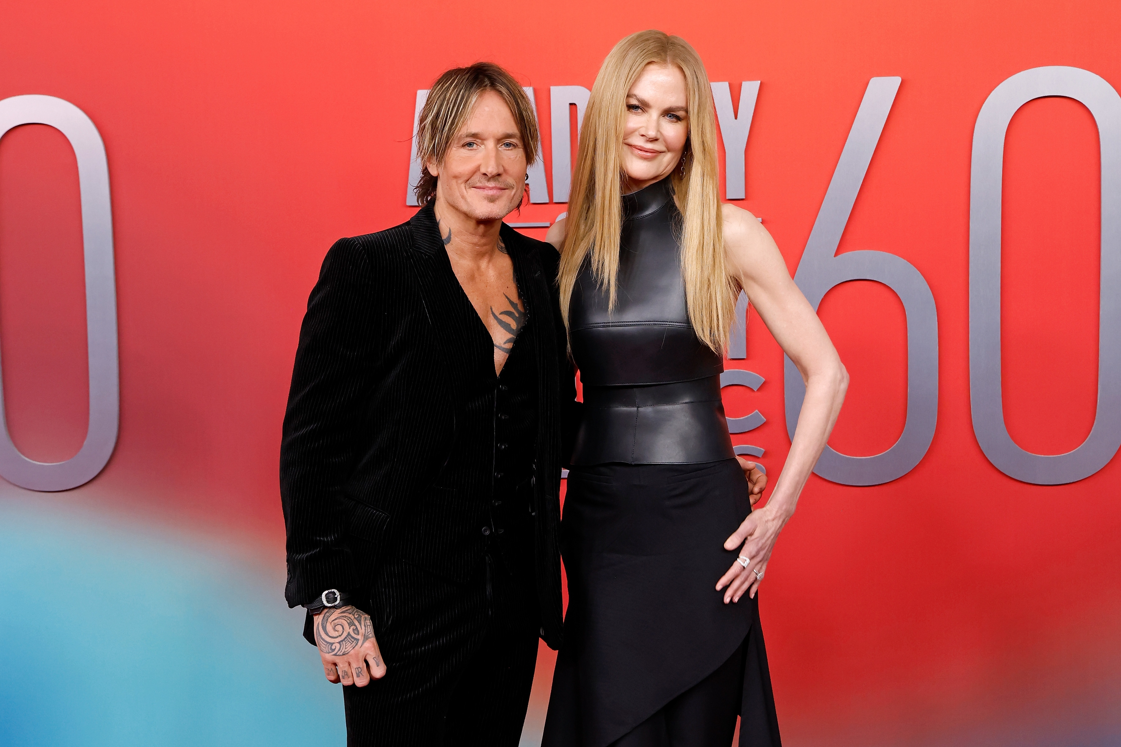 Keith Urban and Nicole Kidman on a red carpet; one in a velvet suit and the other in a sleek, leather-accented dress