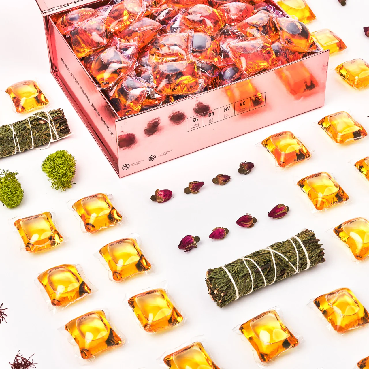 Assorted skincare capsules, dried flowers, and a wrapped herbal bundle arranged on a white surface, suggesting beauty and wellness products