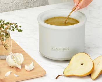 Person utilizing a Crockpot Little Dipper warmer with dip; includes garlic, pear, and herbs, suggesting a snack oregon appetizer setting