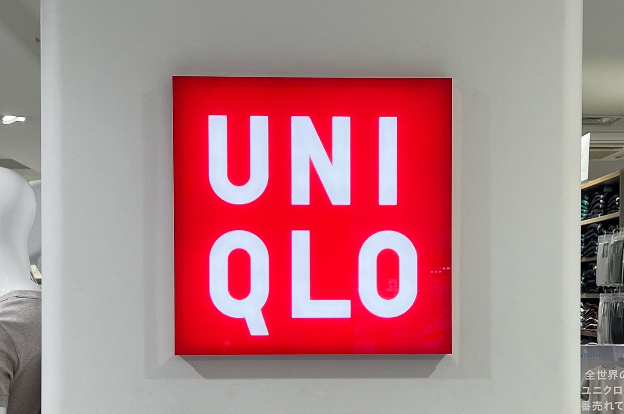 Uniqlo store sign with bold white text on a red background, displayed on an interior wall